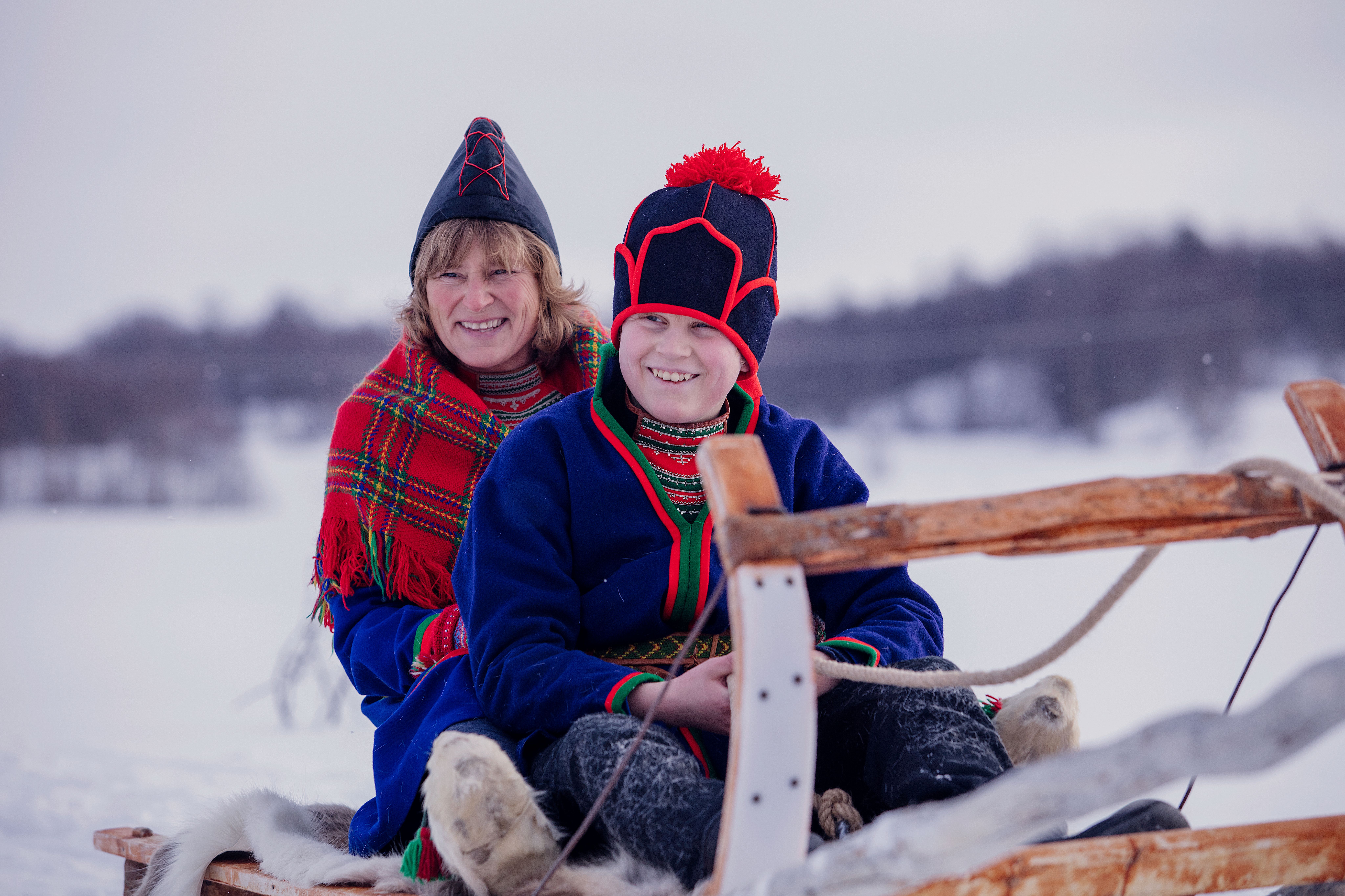 A Sami woman and child on a sled in Røros