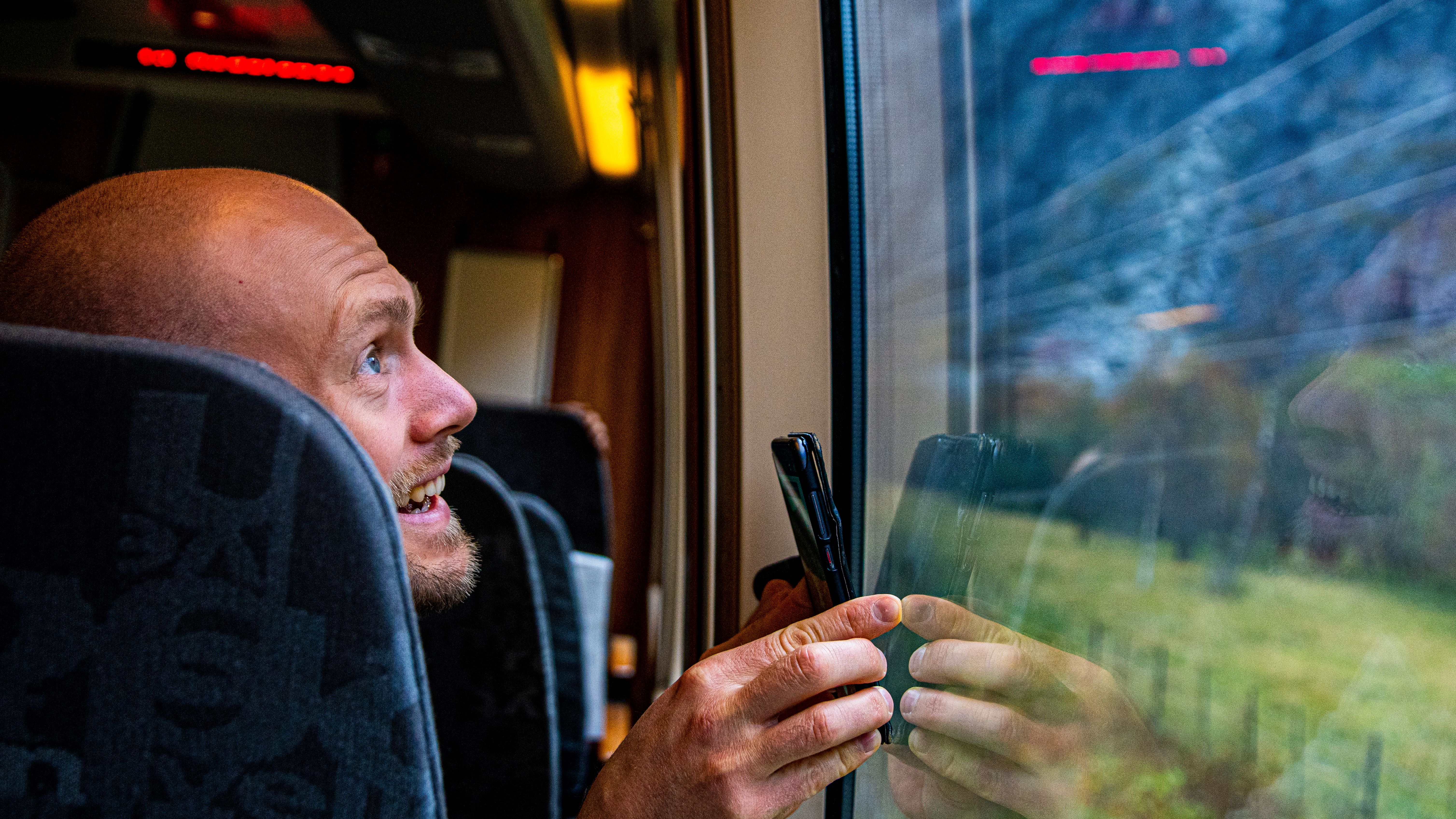 A man looks at the Trollveggen mountain from the Rauma Railway train