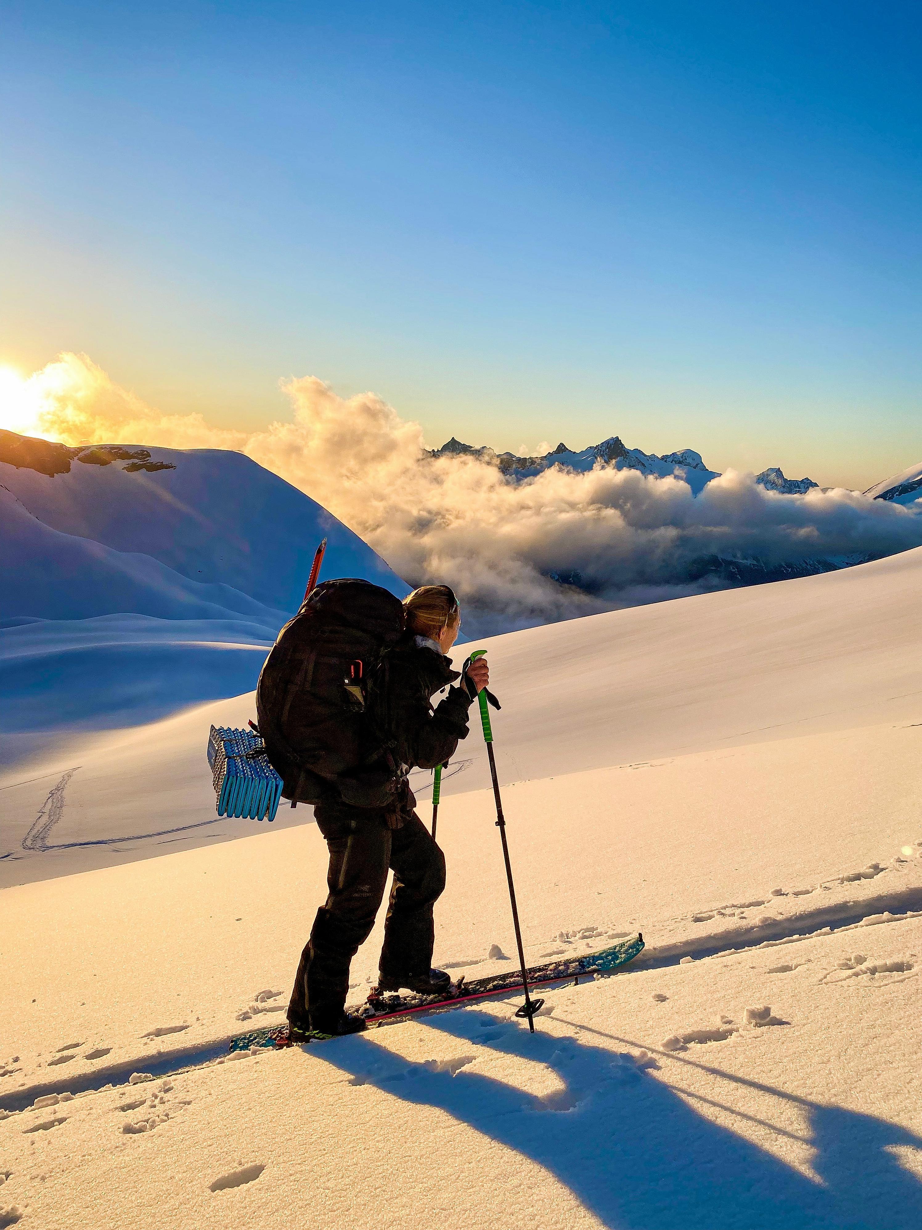 Woman climbing a mountain on randonee skiis in Ørsta, Fjord Norway