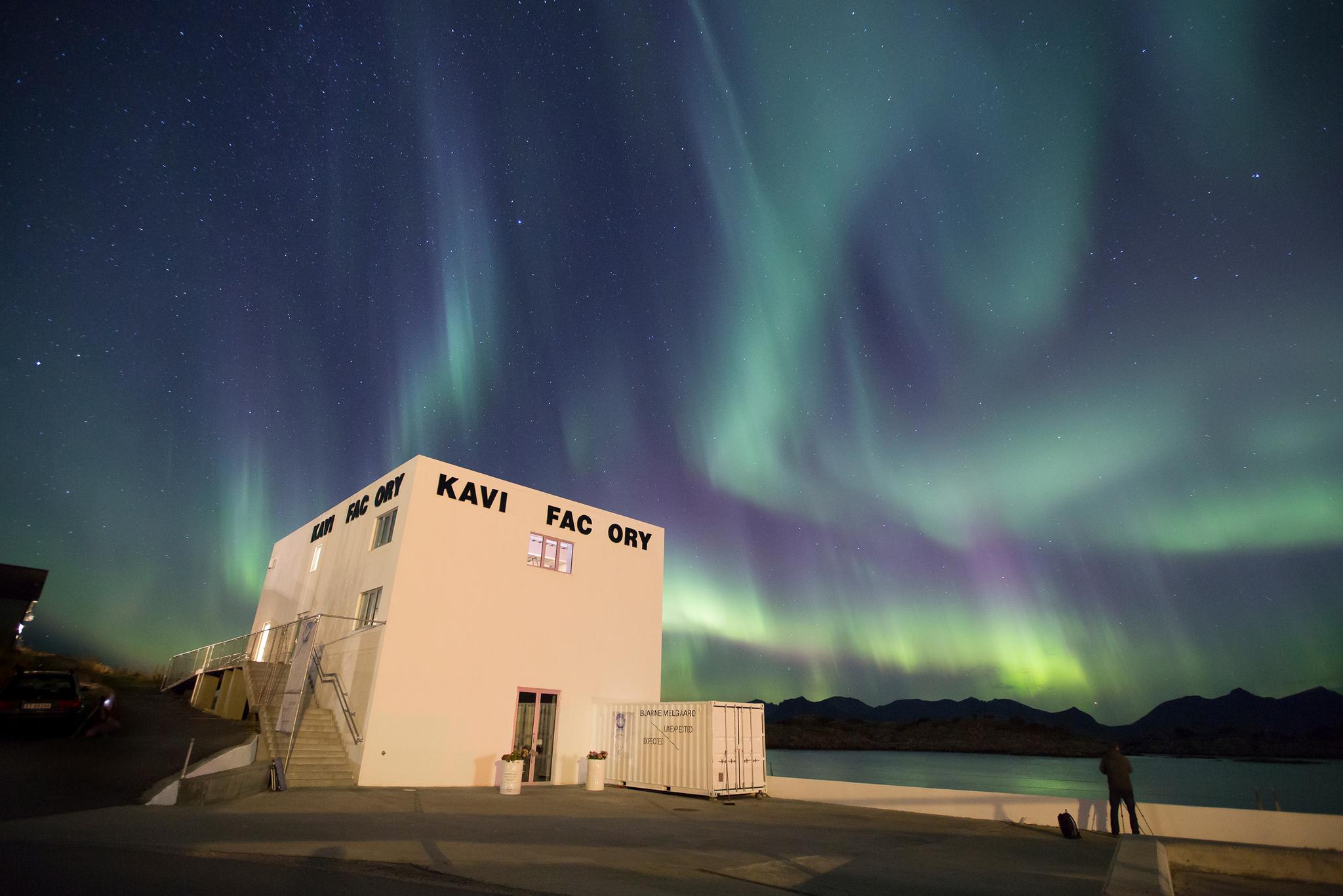 En hvitt bygg som rommer verdenskjent kunst i Lofoten under nordlyset