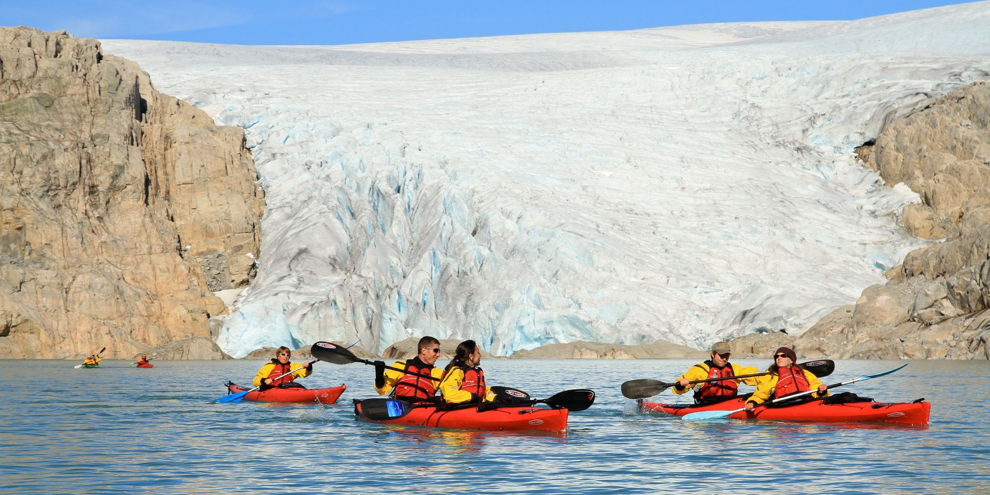 Five people kayaking close to the Folgefonna glacier in Kvinnherad