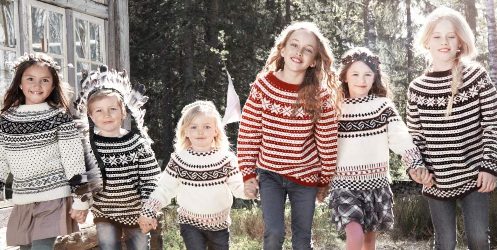 Seks småjenter har på seg strikkegensere fra Rauma Ullvarefabrikk