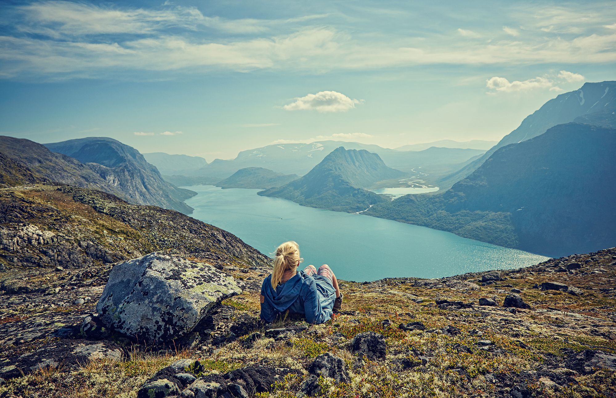 A woman enjoying the view of lake Gjende in the Jotunheimen mountains in Eastern Norway