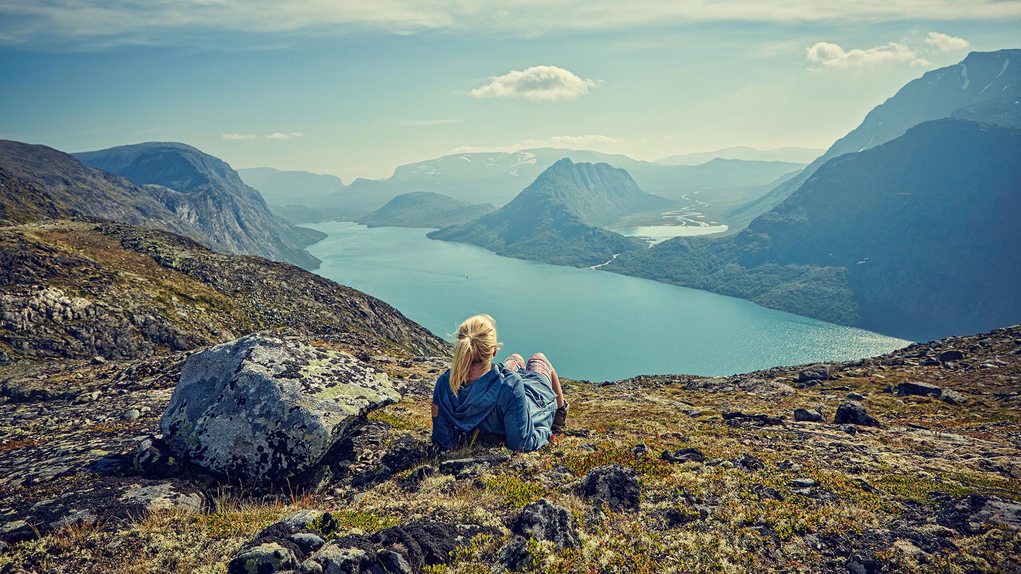 A woman enjoying the view of lake Gjende in the Jotunheimen mountains in Eastern Norway