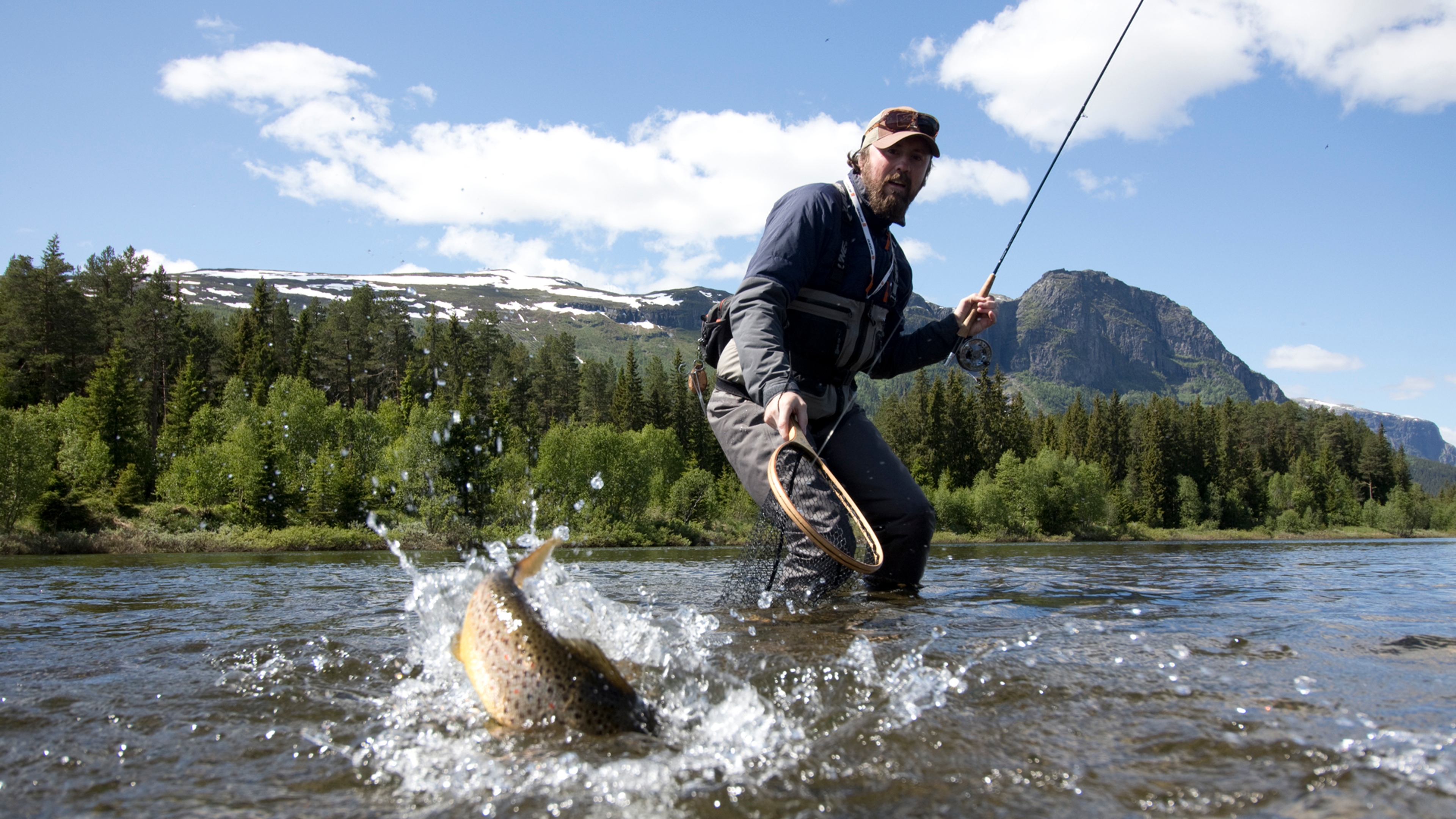 A man catching a fish in a river in Hemsedal, Eastern Norway