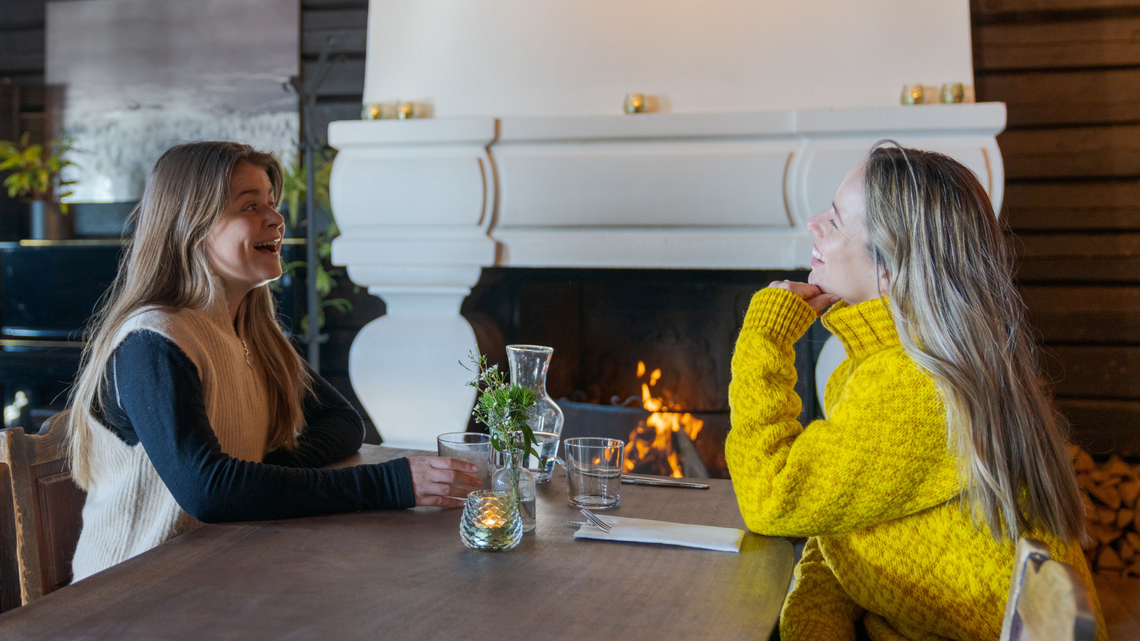 Two friends sitting by the fireplace at the restaurant at Grefsenkollen in Oslo