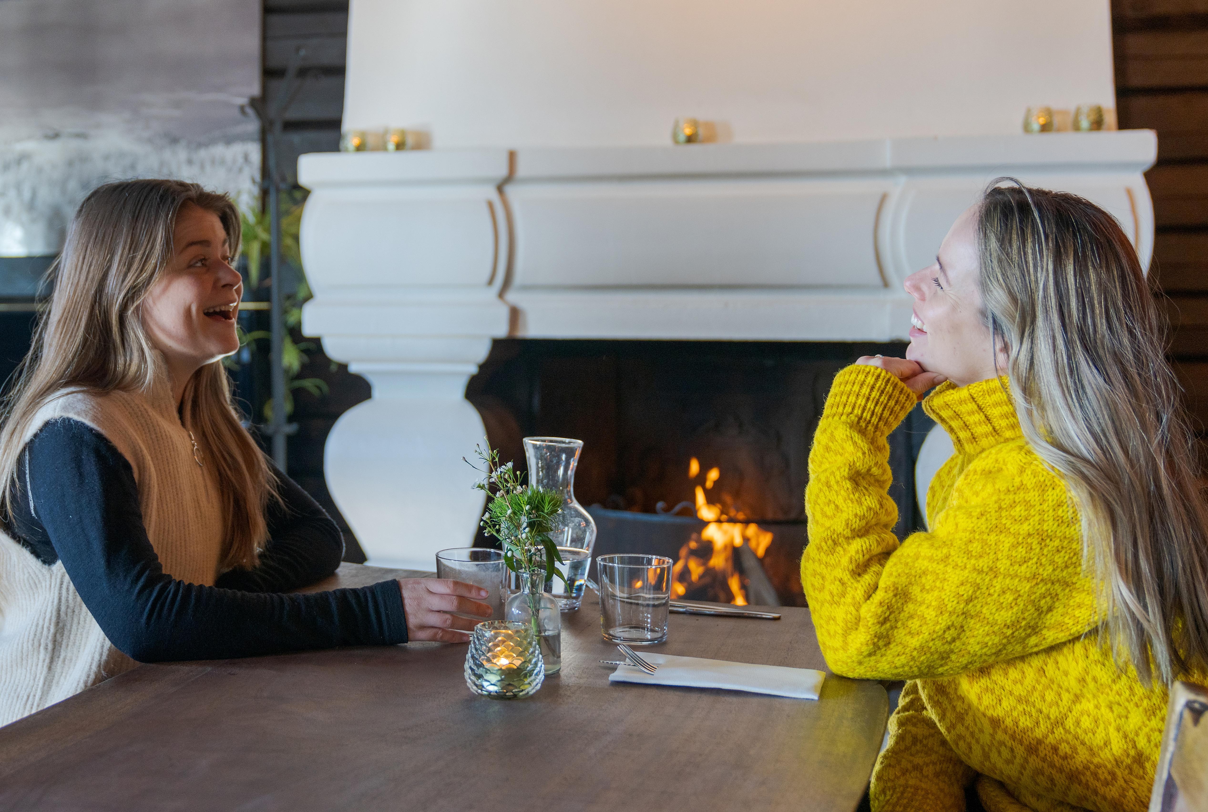 Two friends sitting by the fireplace at the restaurant at Grefsenkollen in Oslo