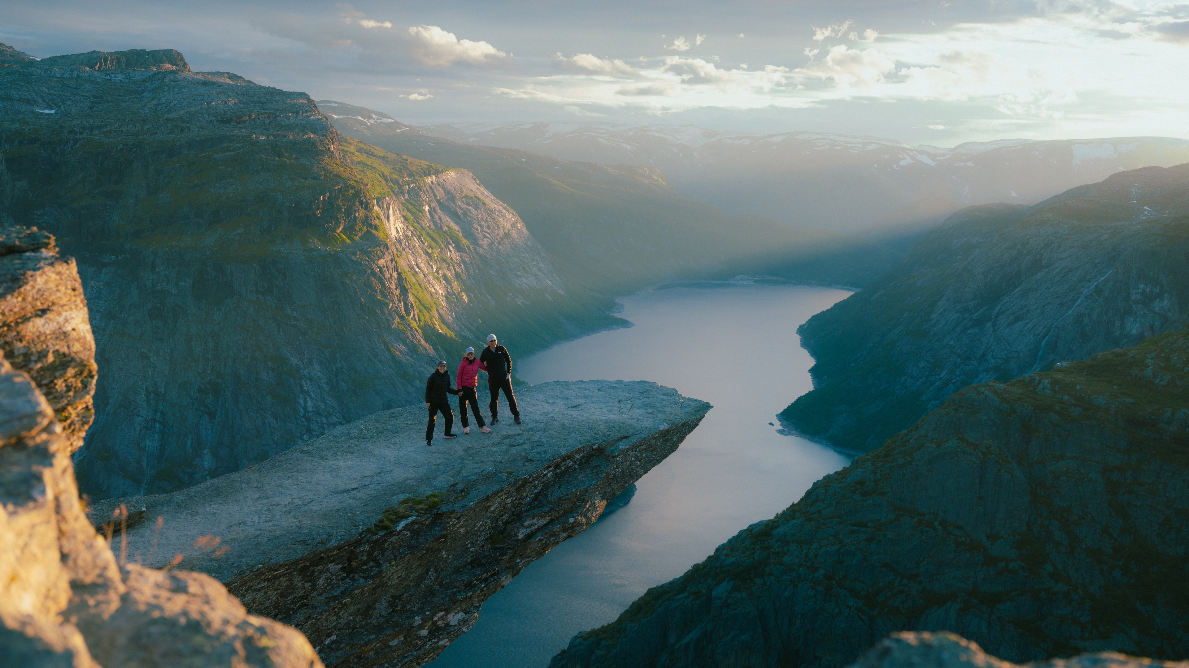 Three people on the mountain formation Trolltunga.