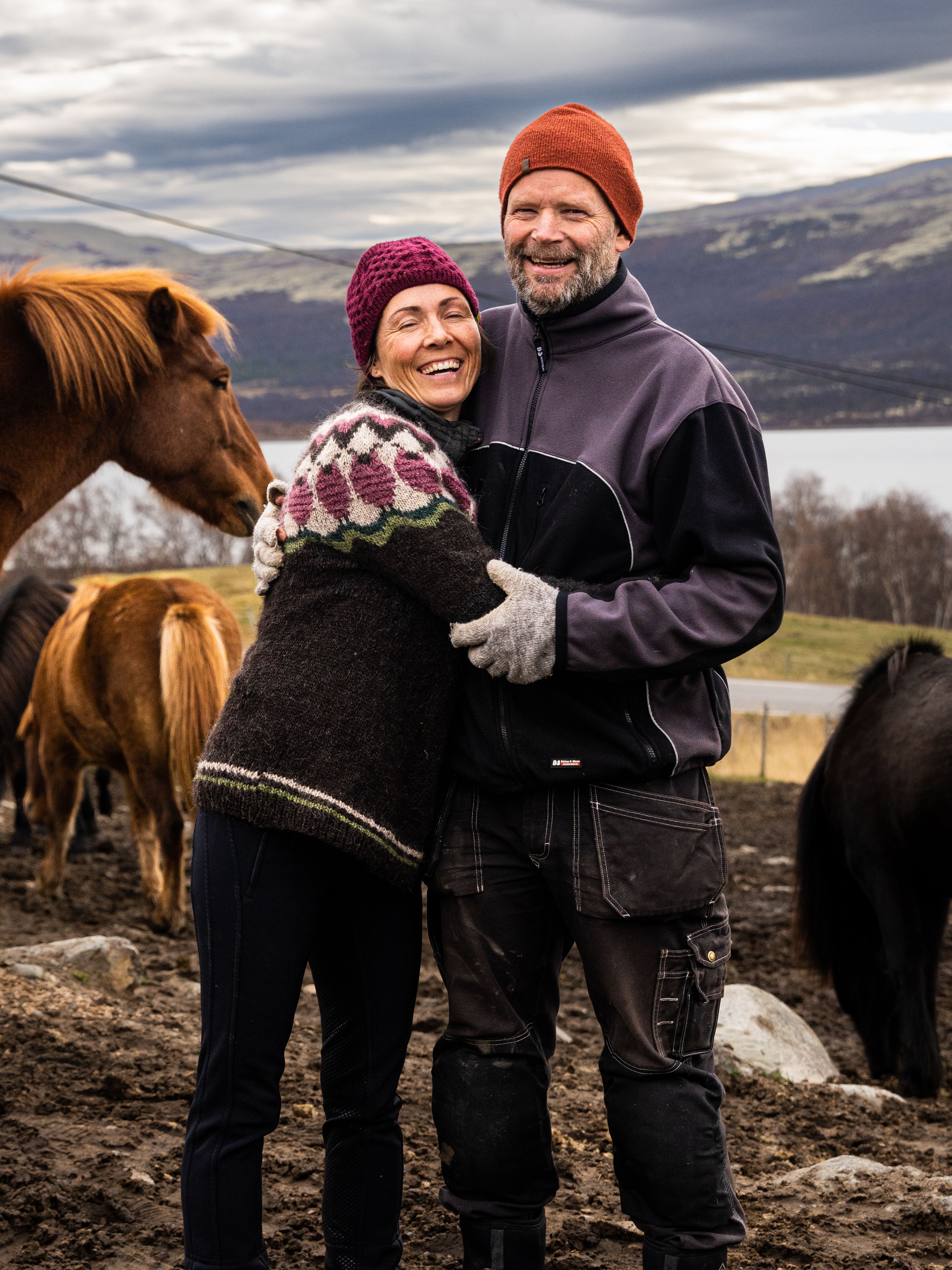 Two people standing with horses at Hjerkinn Fjellstue, moutain lodge, at Dovrefjell mountain.