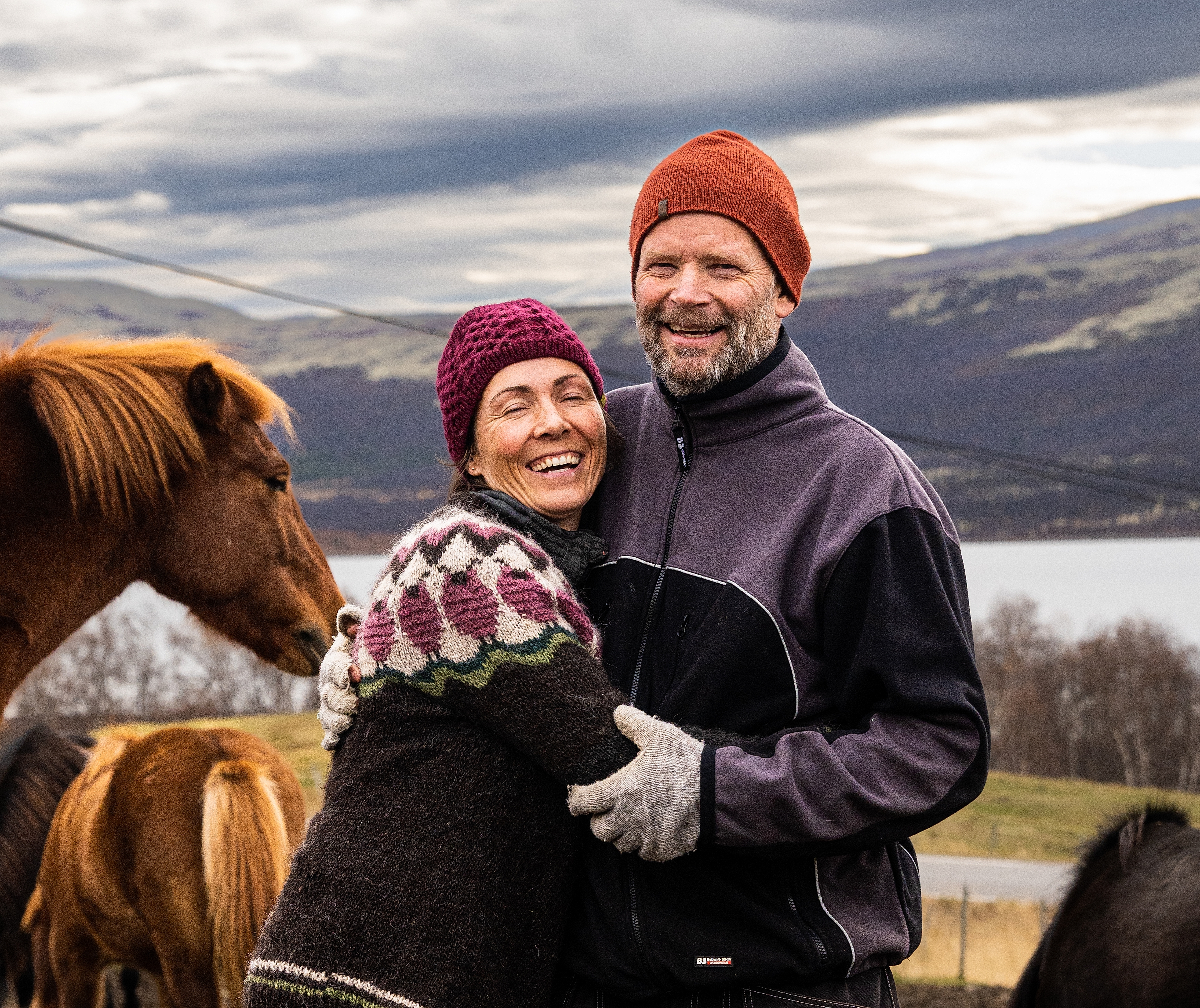 Two people standing with horses at Hjerkinn Fjellstue, moutain lodge, at Dovrefjell mountain.