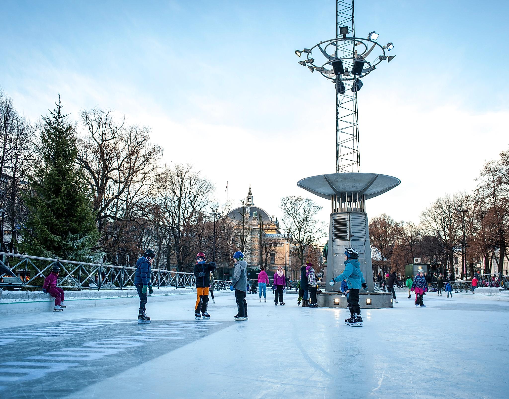 Kids ice skating at the ice rink in the middle of Oslo city, Norway