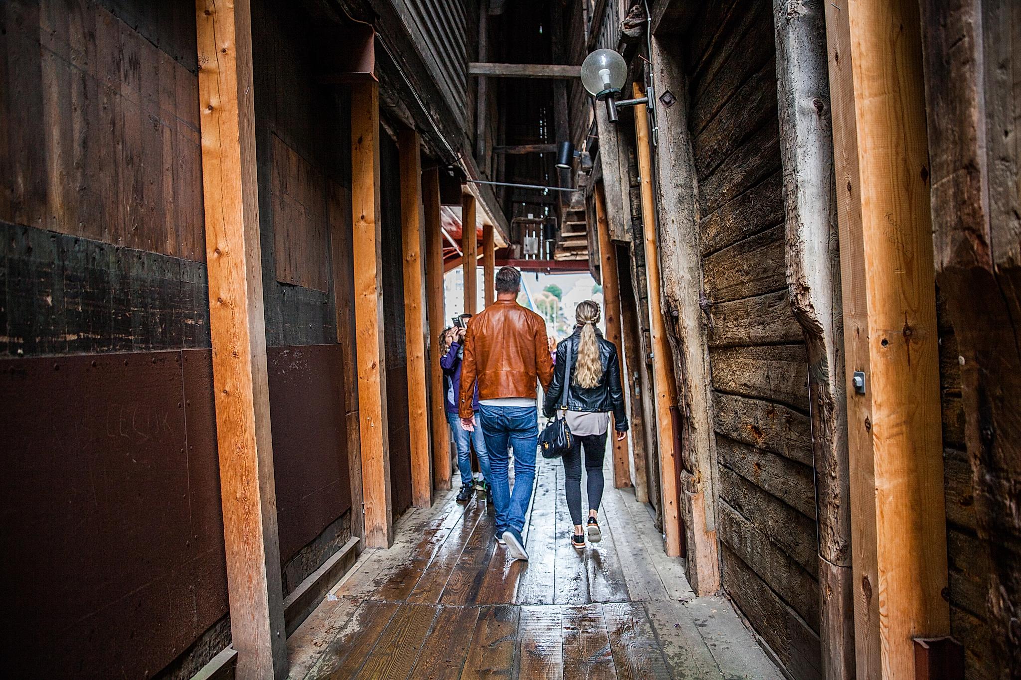 A couple walking through the narrow passages in Bryggen in Bergen.