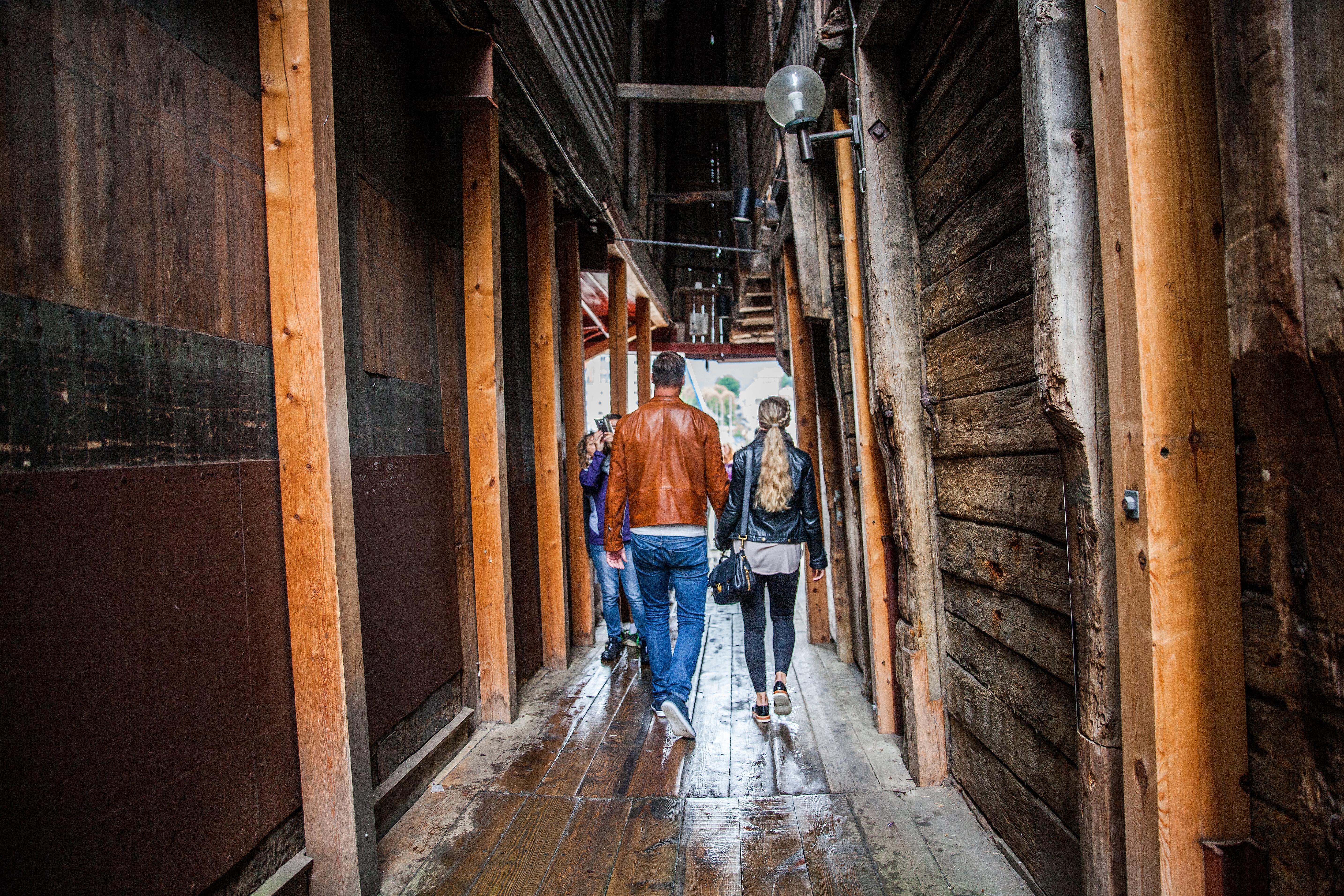 A couple walking through the narrow passages in Bryggen in Bergen.