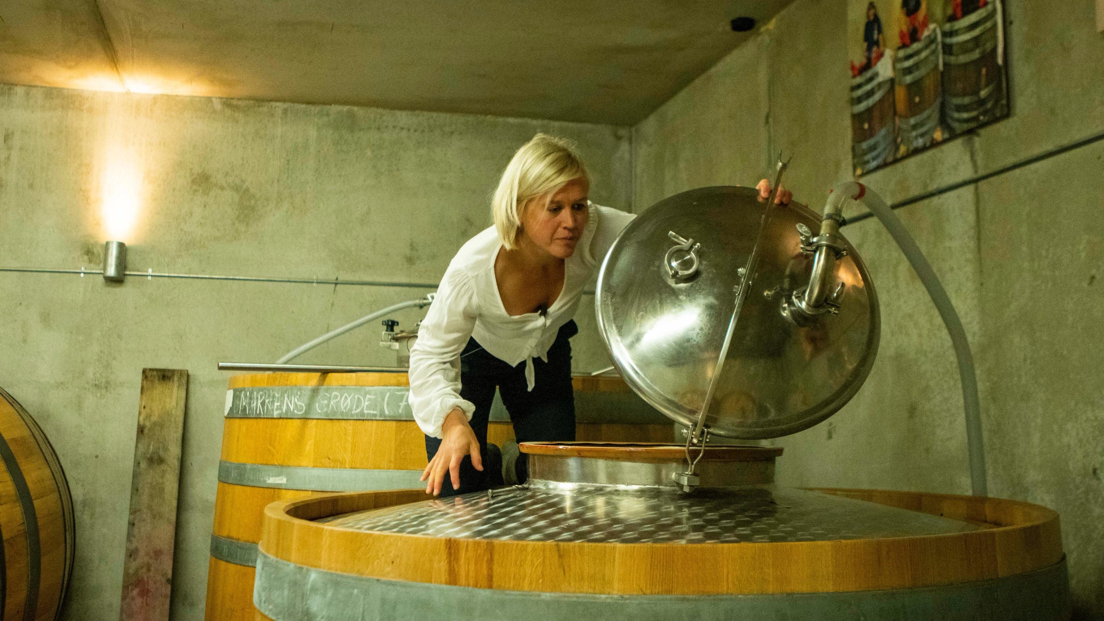 Ingeborg Lindheim standing on a oak barrel in the cider- and beer cellar.