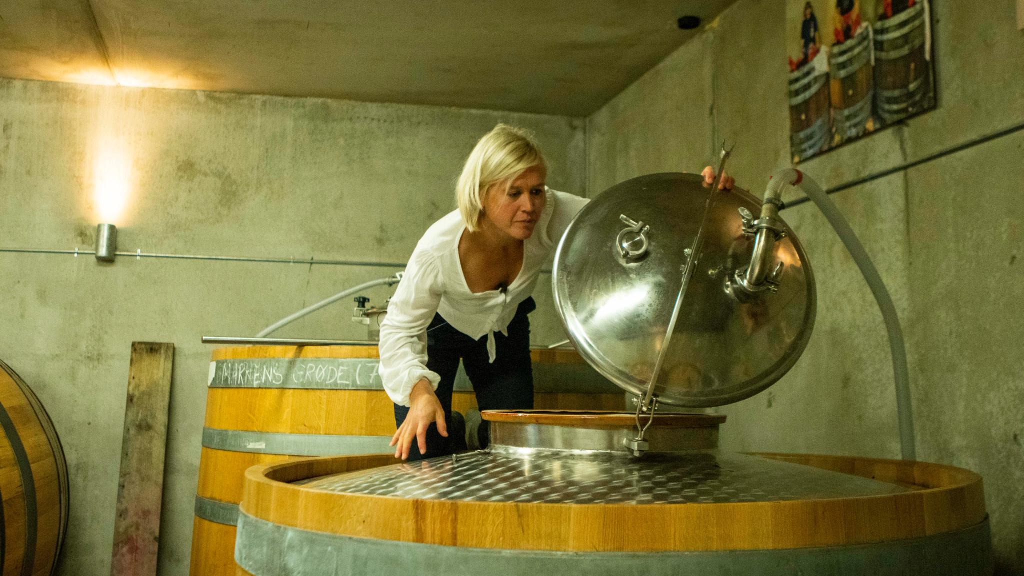 Ingeborg Lindheim standing on a oak barrel in the cider- and beer cellar.