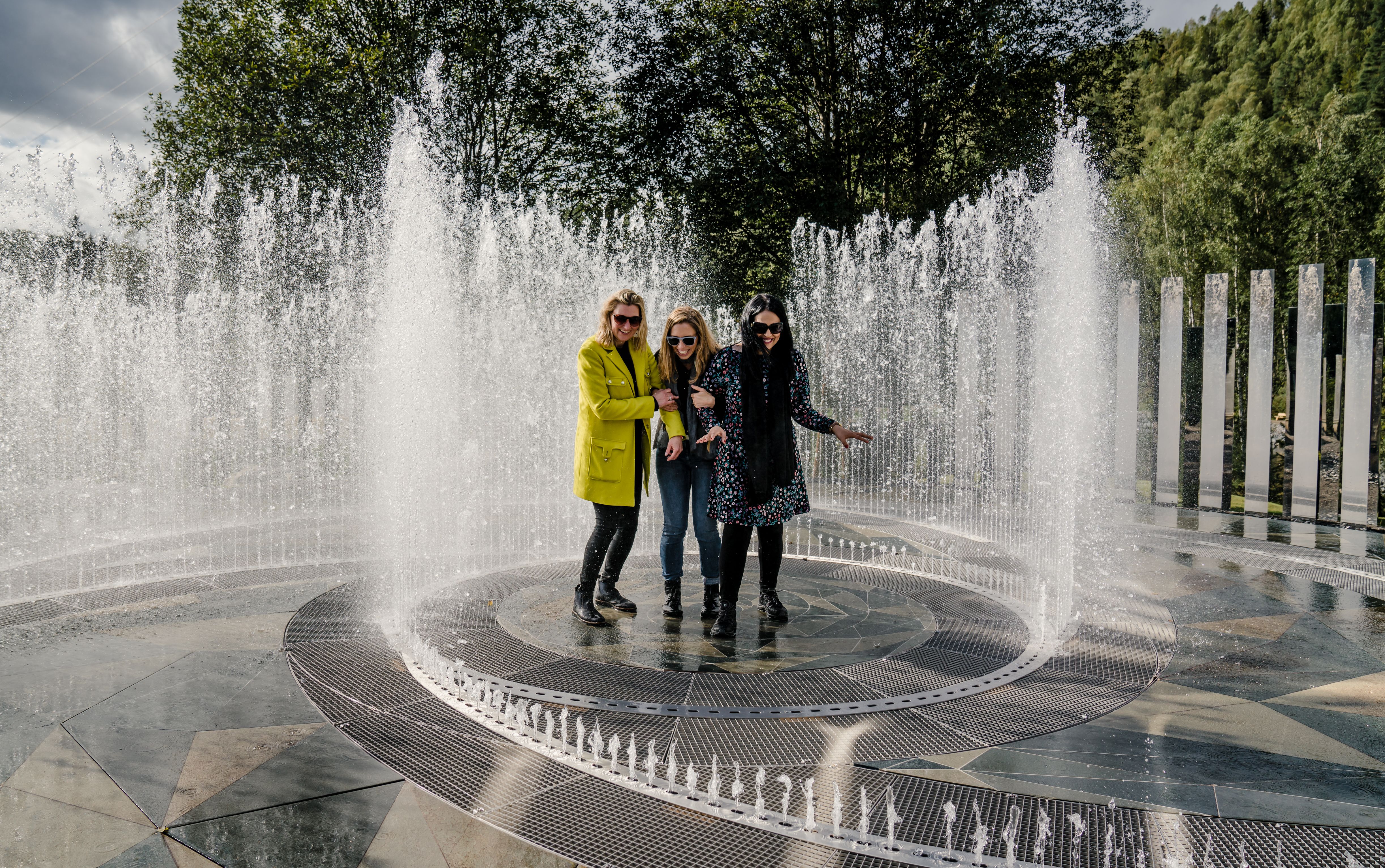 Fyra skrattande kvinnor står i fontänen som omges av speglar på Kistefos Museum i Hadeland