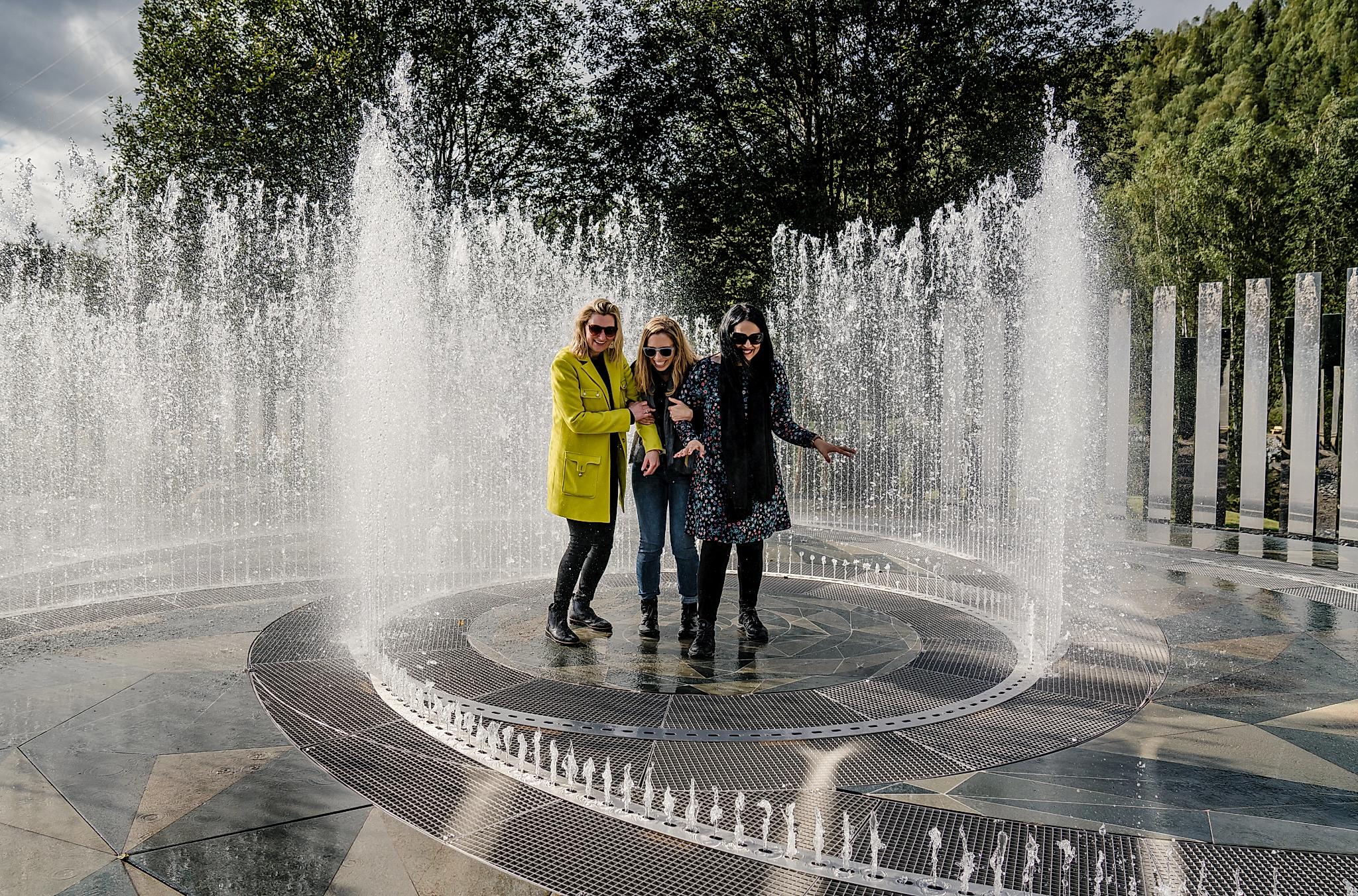 Fyra skrattande kvinnor står i fontänen som omges av speglar på Kistefos Museum i Hadeland
