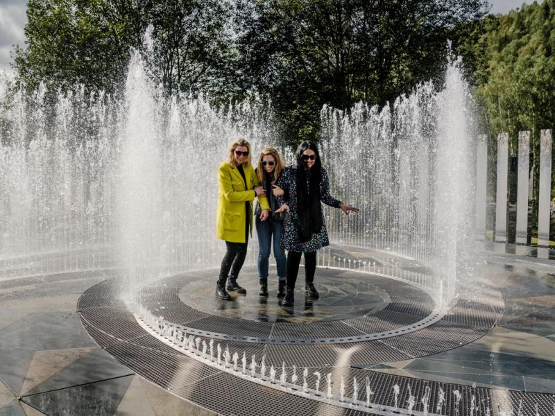 Fyra skrattande kvinnor står i fontänen som omges av speglar på Kistefos Museum i Hadeland