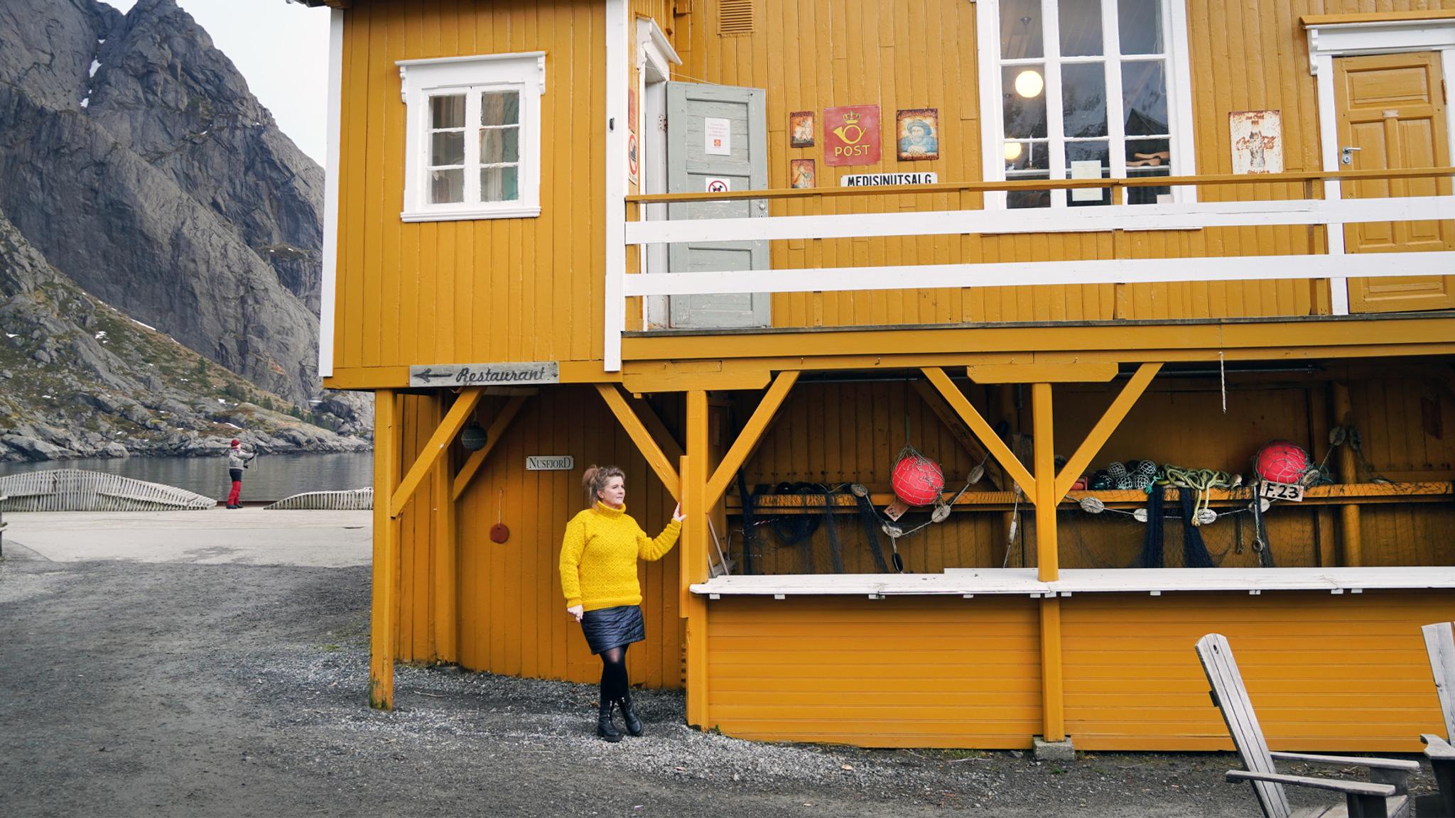 Woman outside the Nusfjord Landhandel shop