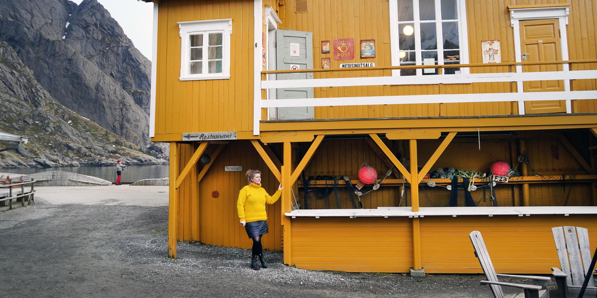 Woman outside the Nusfjord Landhandel shop