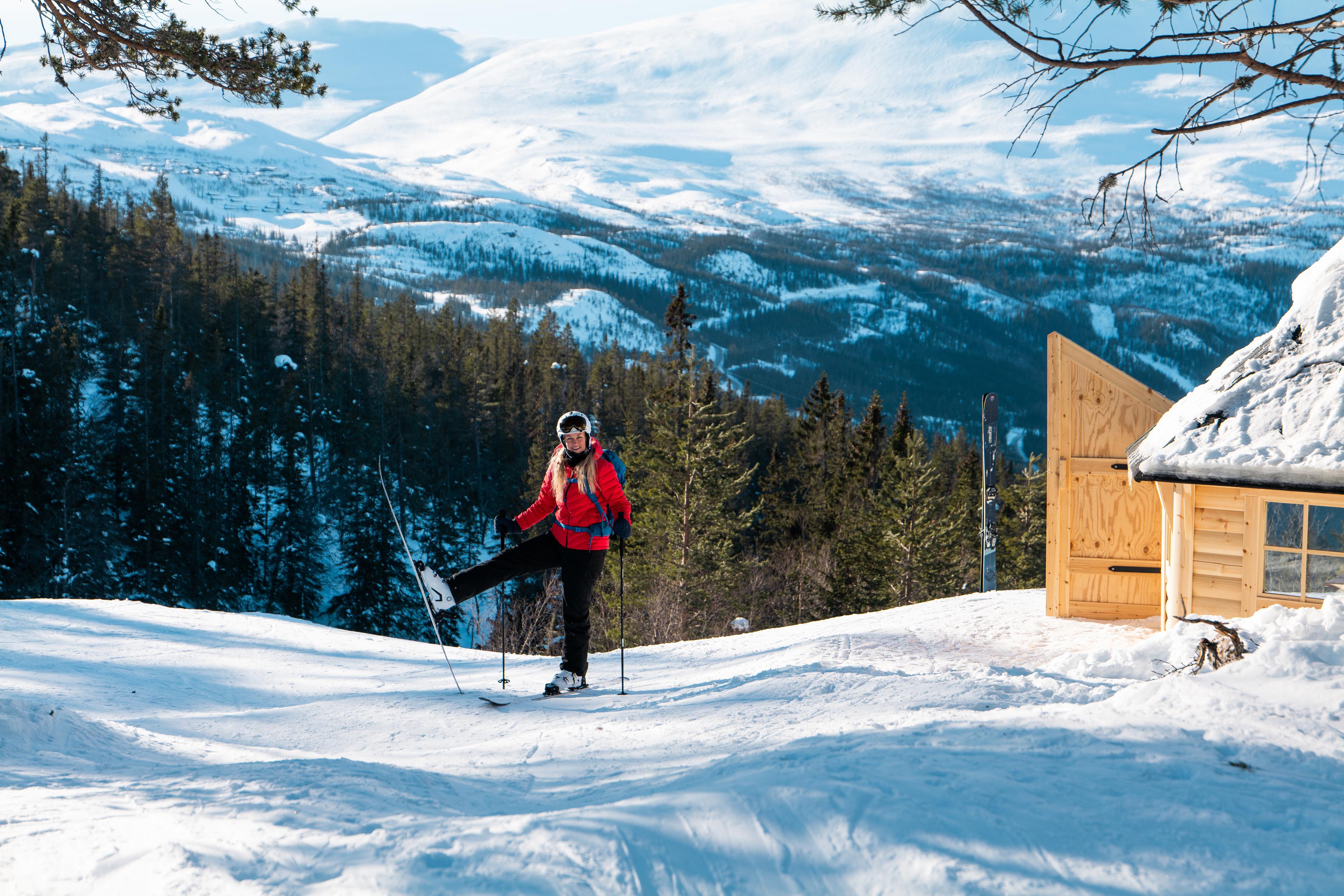 Woman on skis outside cabin in Telemark