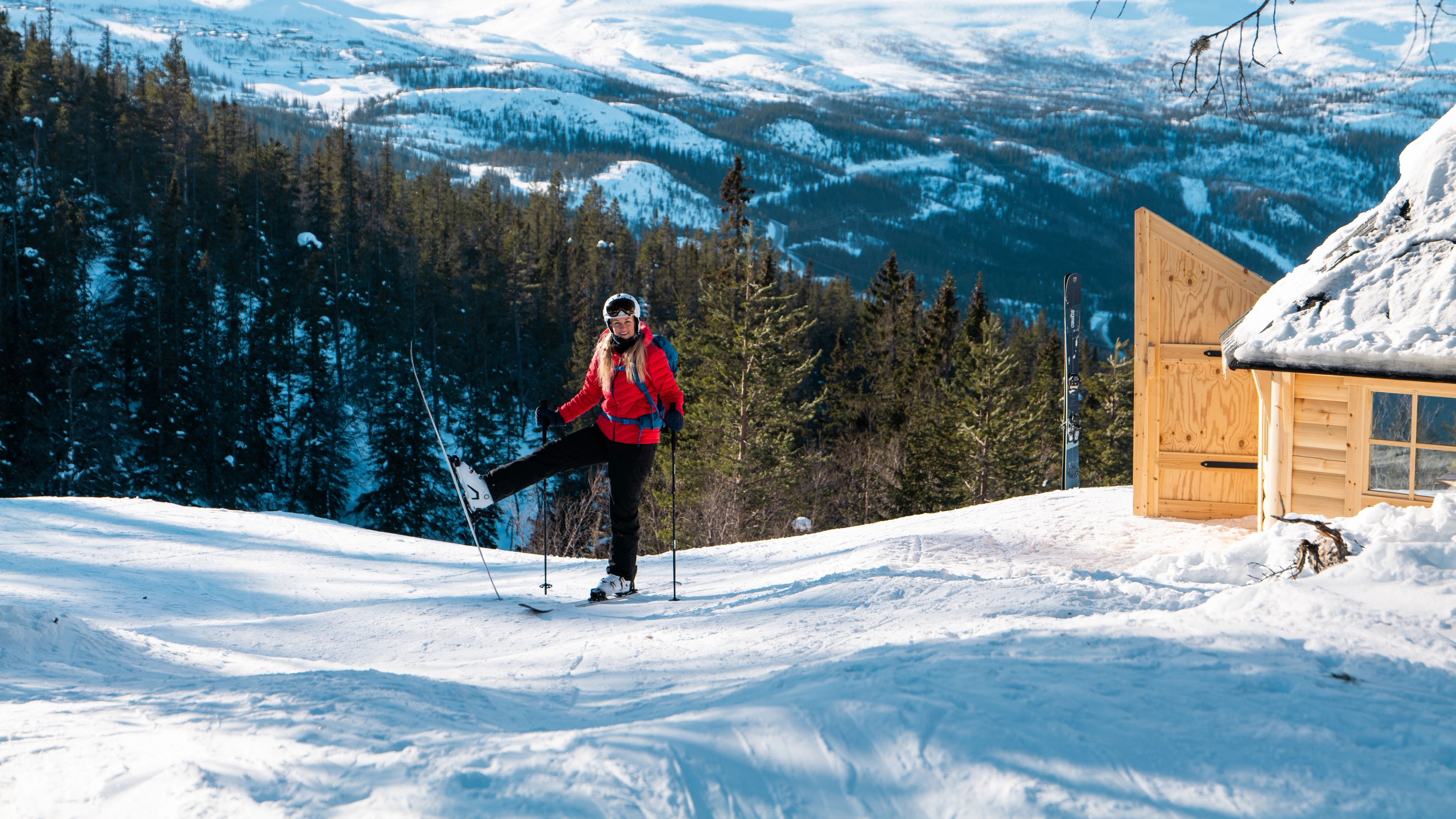 Woman on skis outside cabin in Telemark