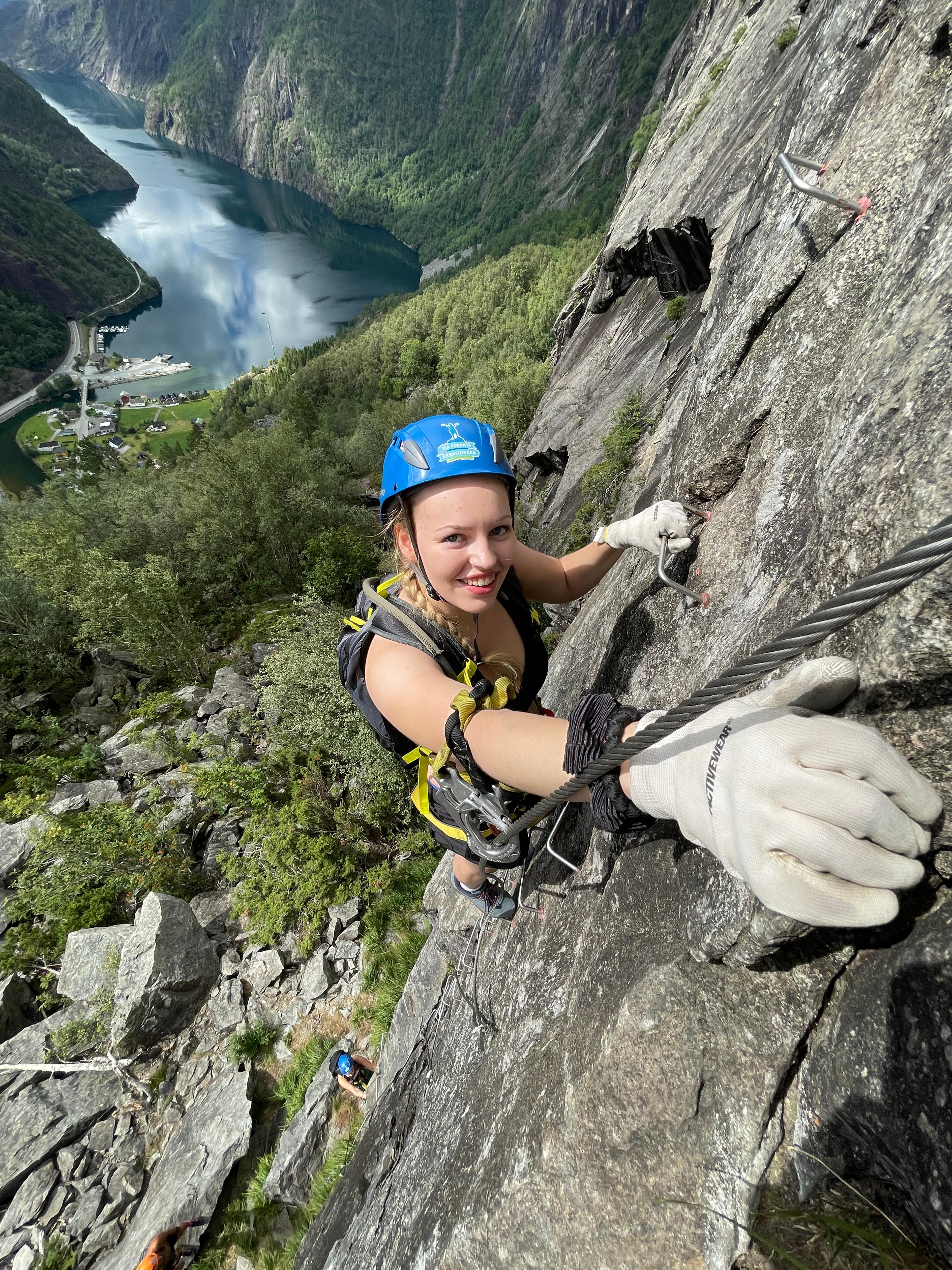 Woman climbing via ferrata in Kyrkjeveggen