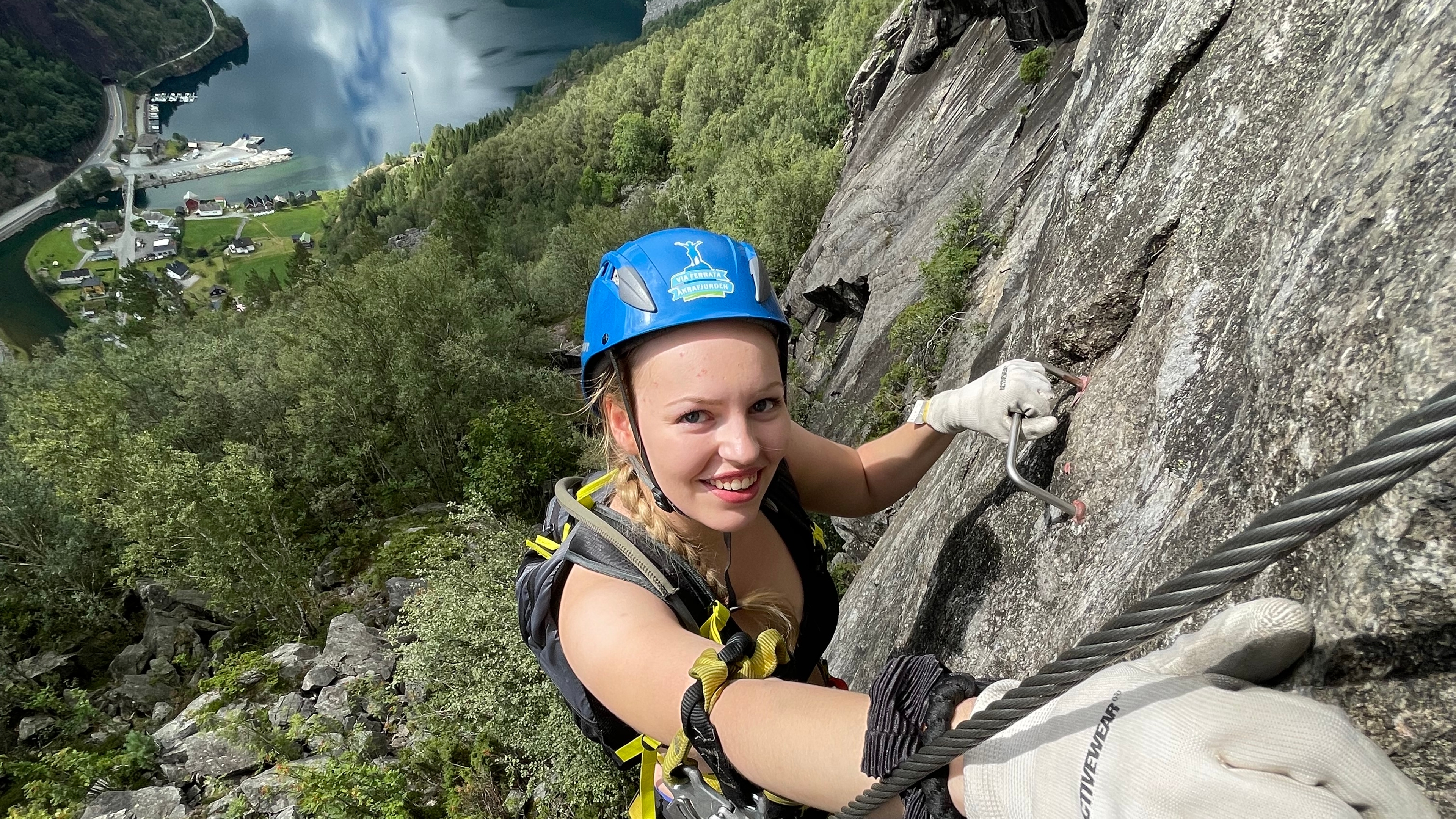 Kvinne klatrer via ferrata Kyrkjeveggen
