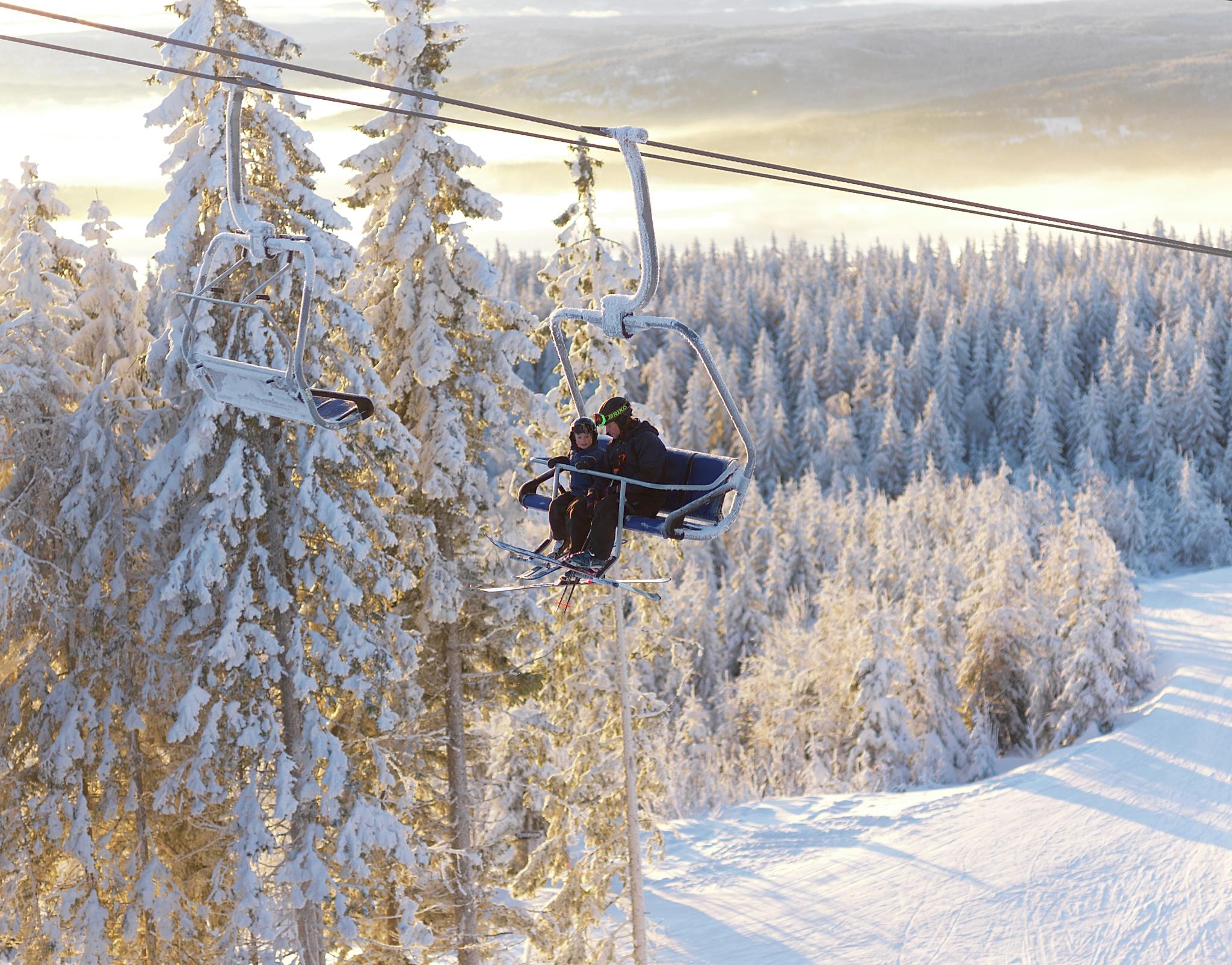 Two people taking the lift at Skimore Oslo, Tryvann