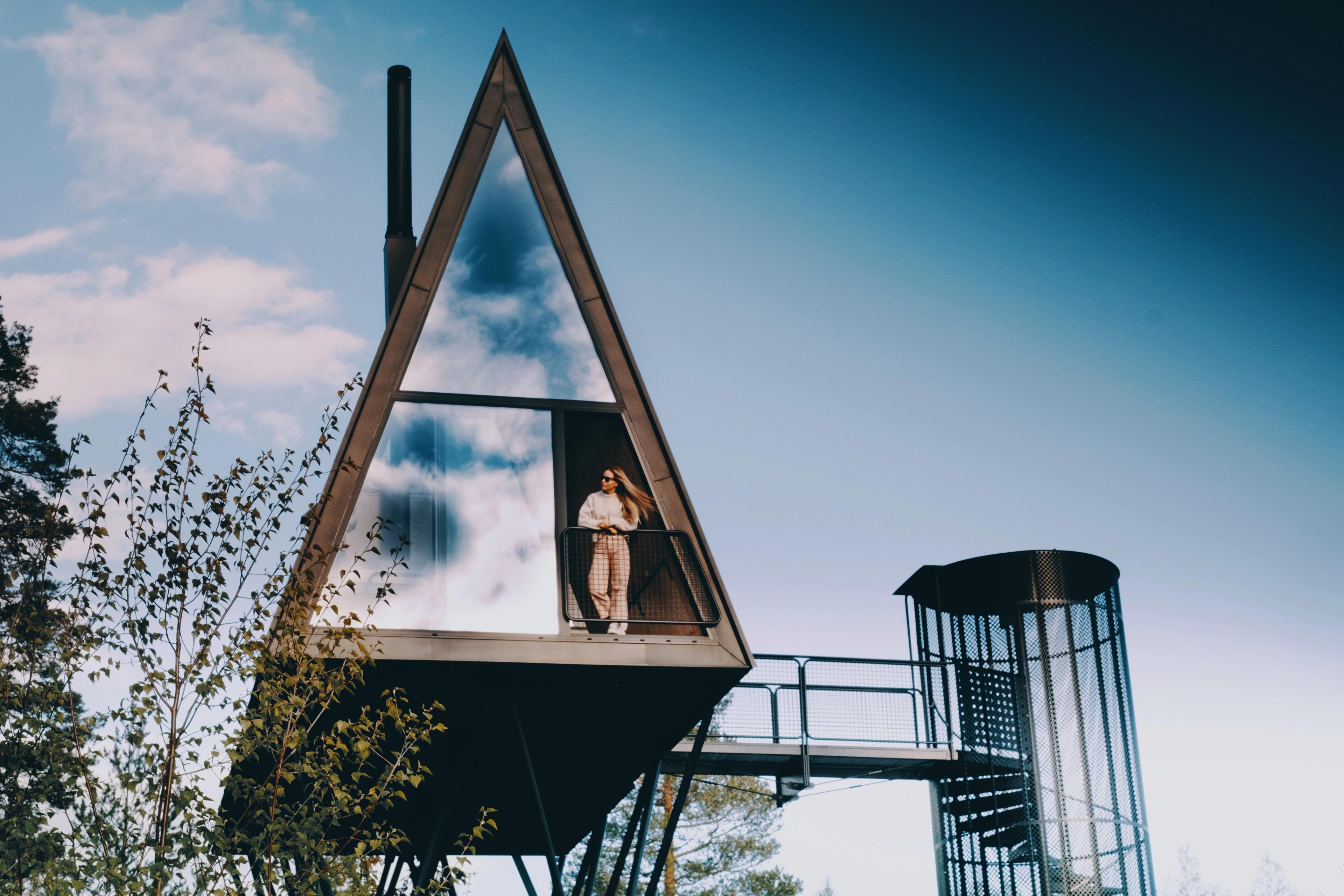 A woman is enjoying the view from one of the treehouses at PAN treetop cabins in Finnskogen, Eastern Norway