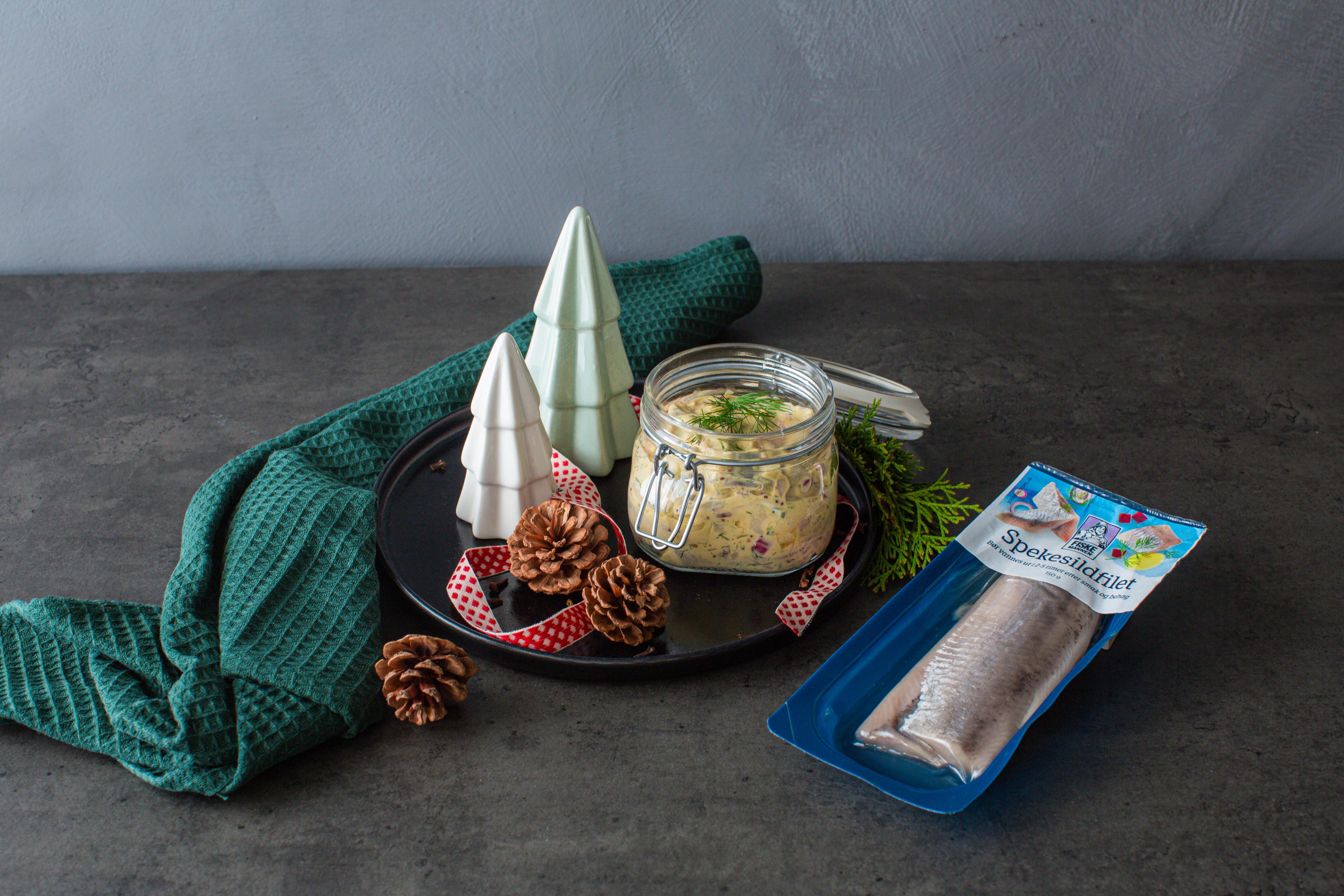Traditional Norwegian pickled herring in a glass jar.