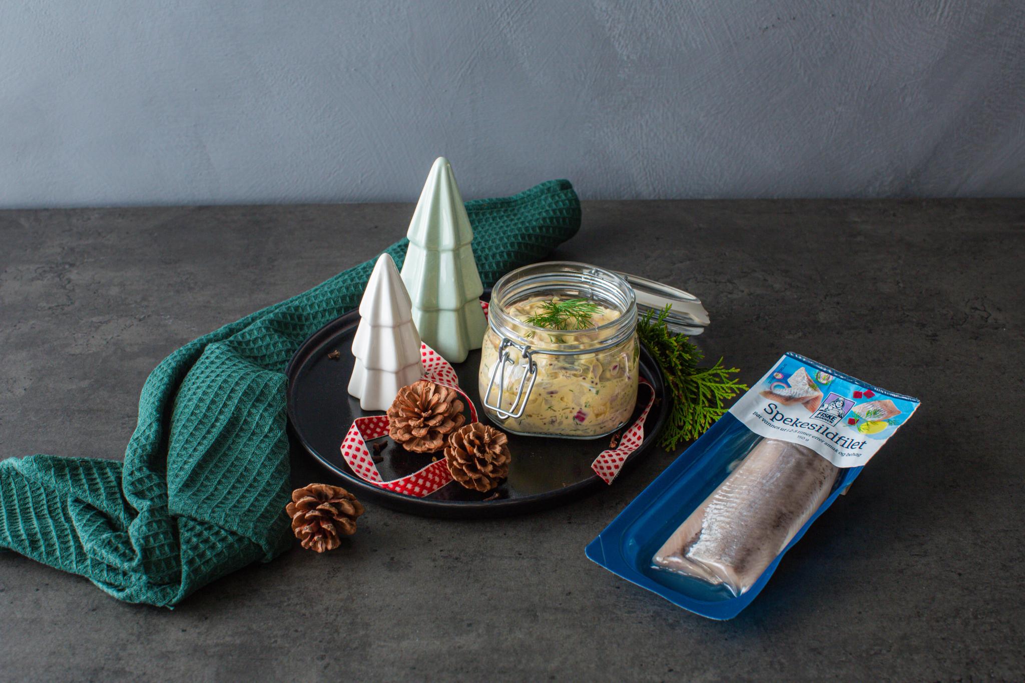 Traditional Norwegian pickled herring in a glass jar.