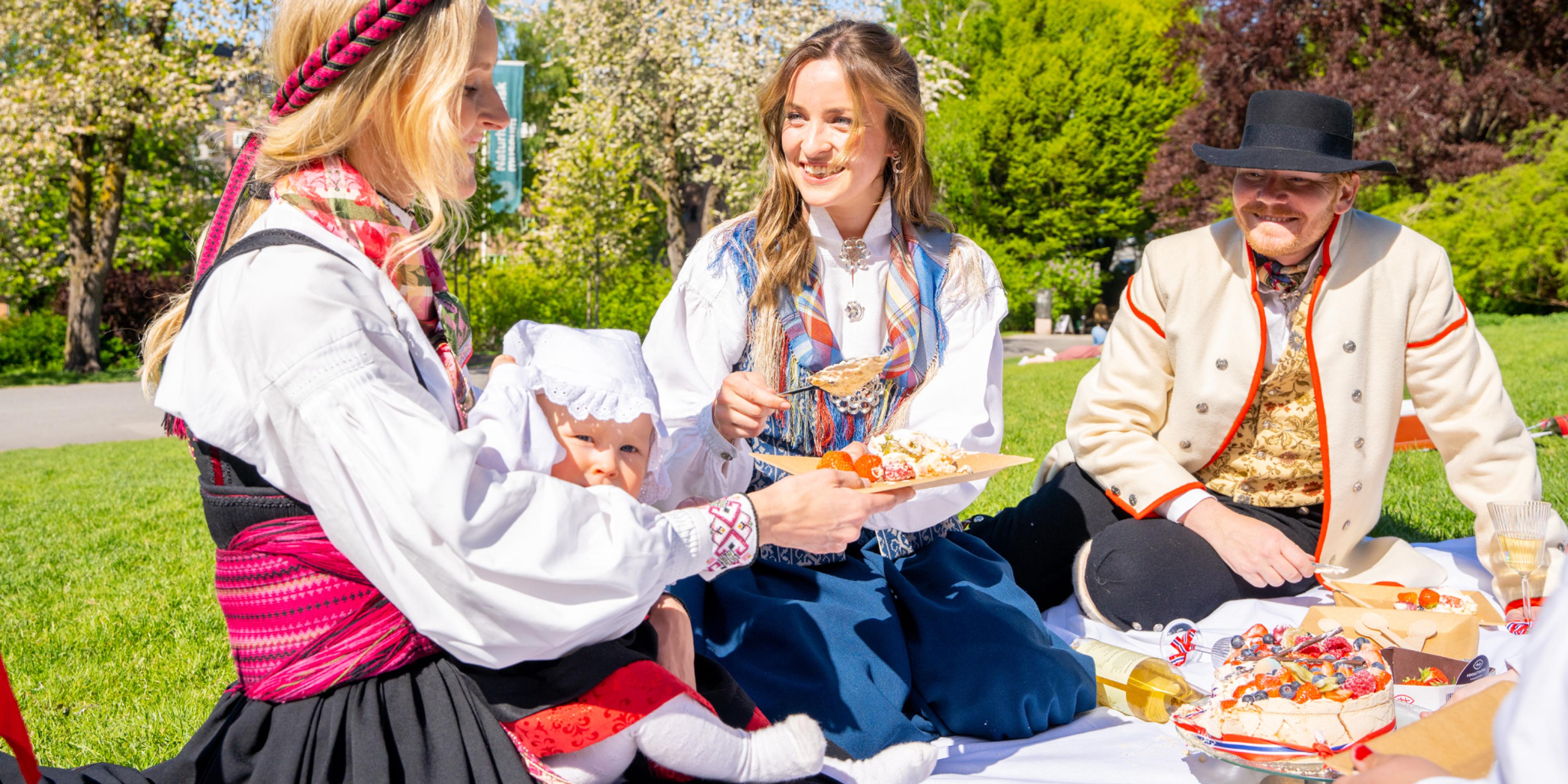 People enjoying festive food in the park wearing bunads on 17 of May - Norway’s national day