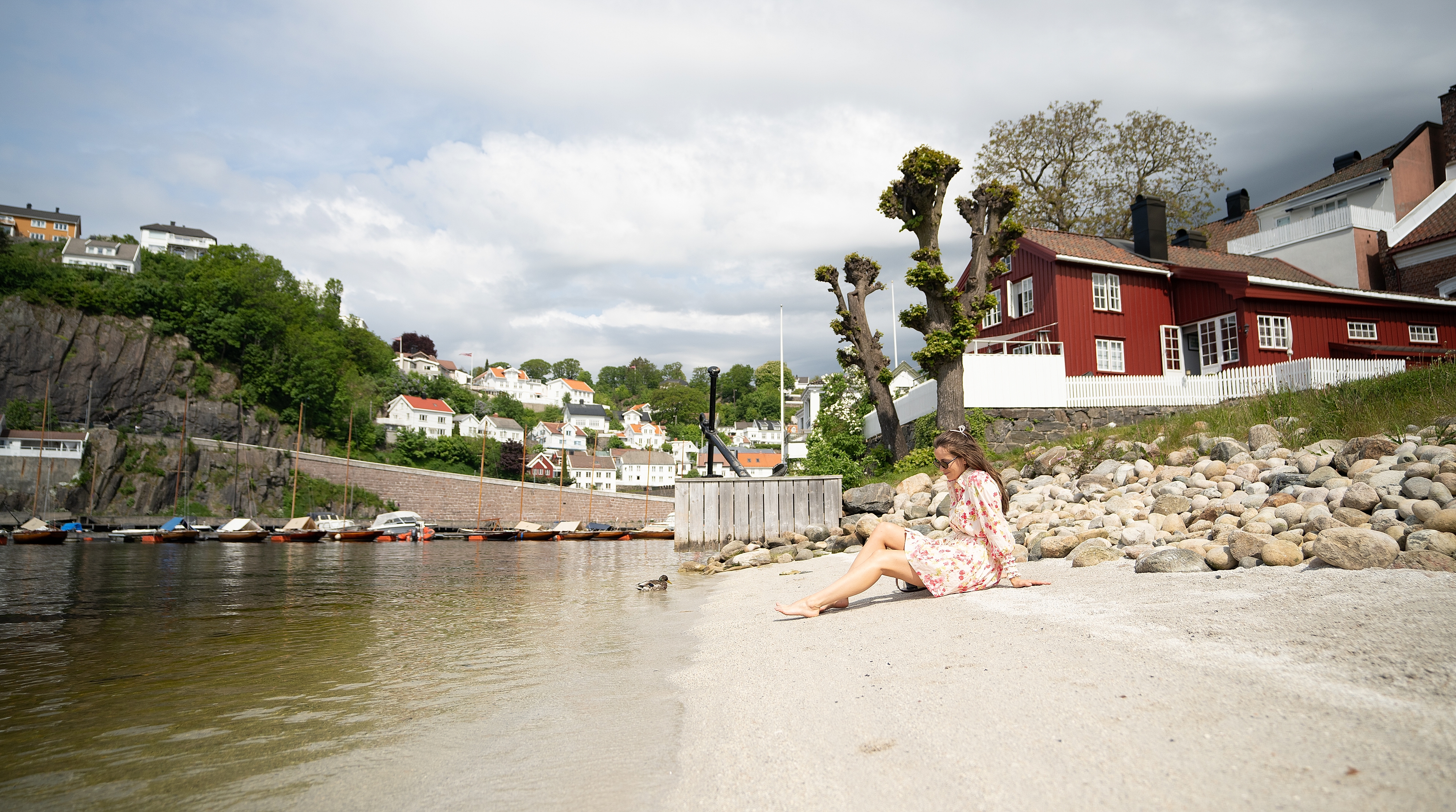 Girl sitting on a beach at Tyholmen in Arendal, Southern Norway