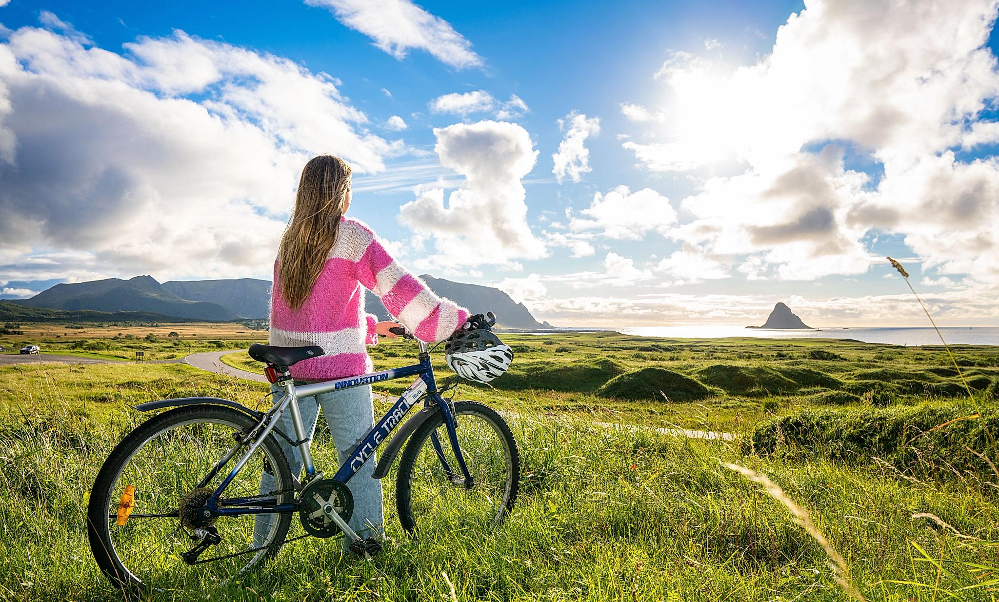 En dame sykler langs Nasjonal turistvei Andøya