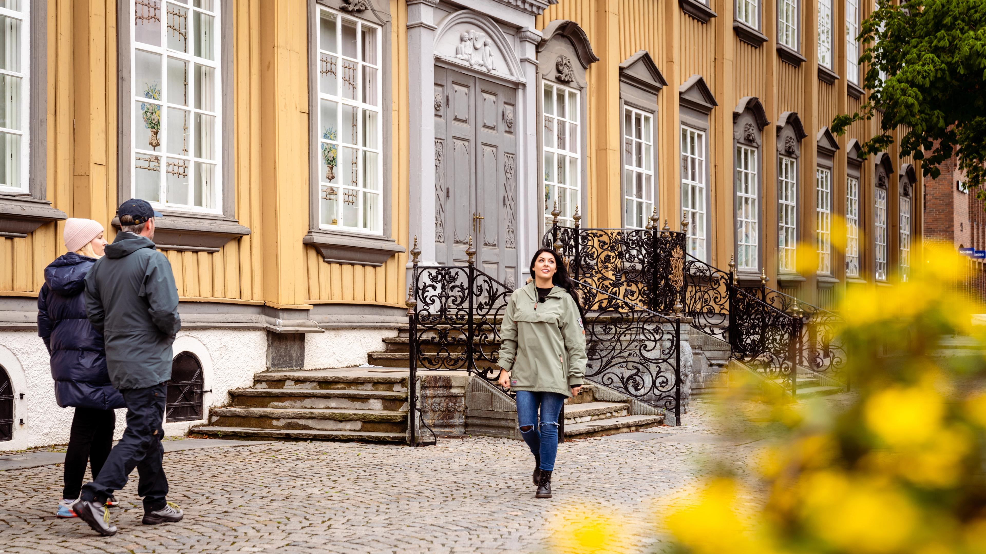 A woman walking past Stiftsgården in Trondheim