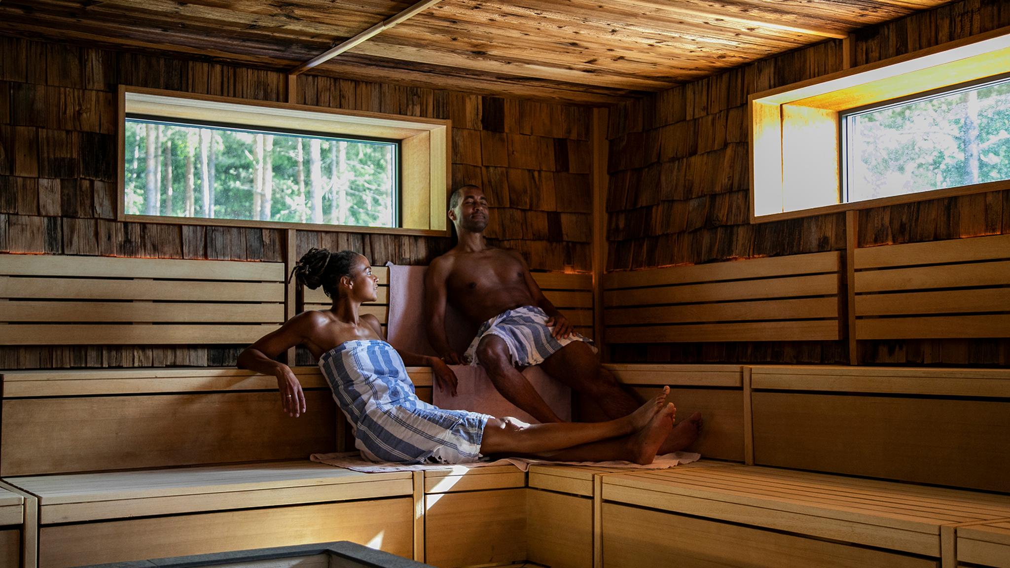 A couple relaxing in the forest sauna at The Well outside of Oslo in Eastern Norway