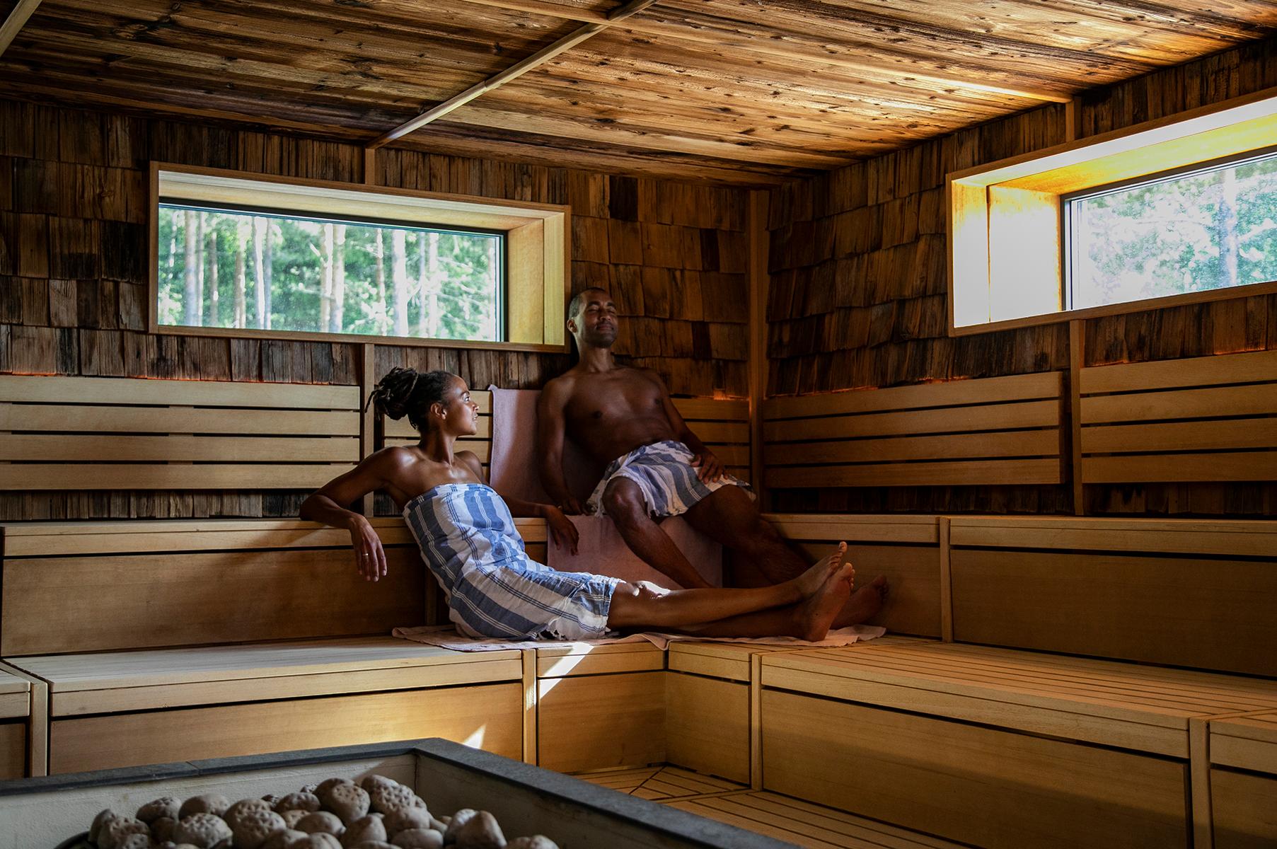 A couple relaxing in the forest sauna at The Well outside of Oslo in Eastern Norway