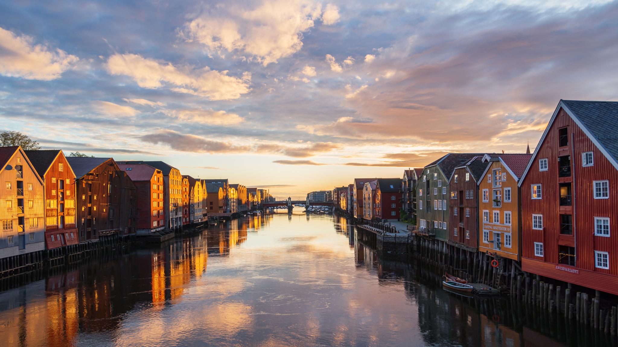 Solnedgang over de gamle trehusene langs Nidelva, som renner tvers gjennom Trondheim i Trøndelag