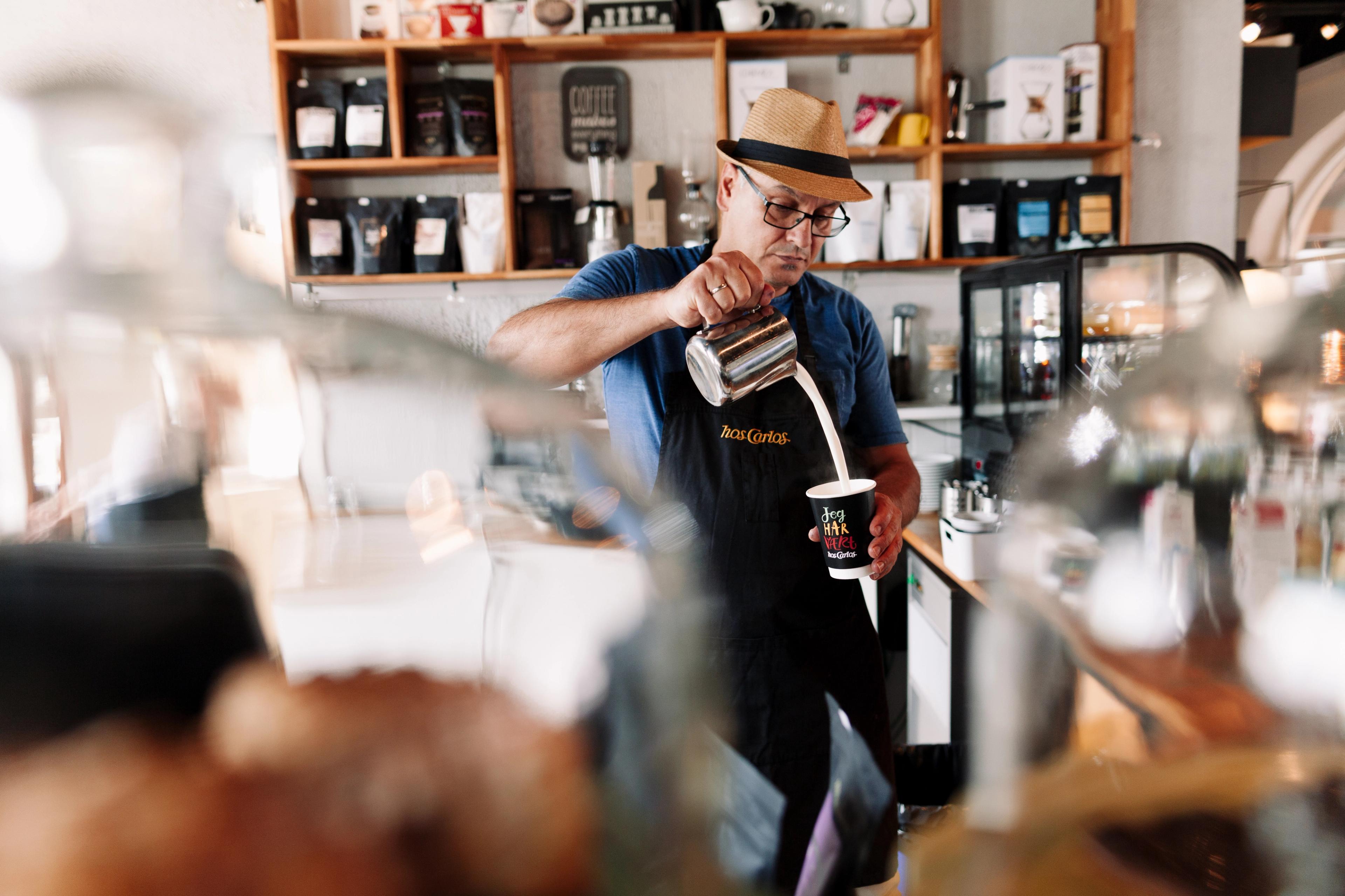The barista at café Hos Carlos in Haugesund, Fjord Norway, is making a cup of coffee