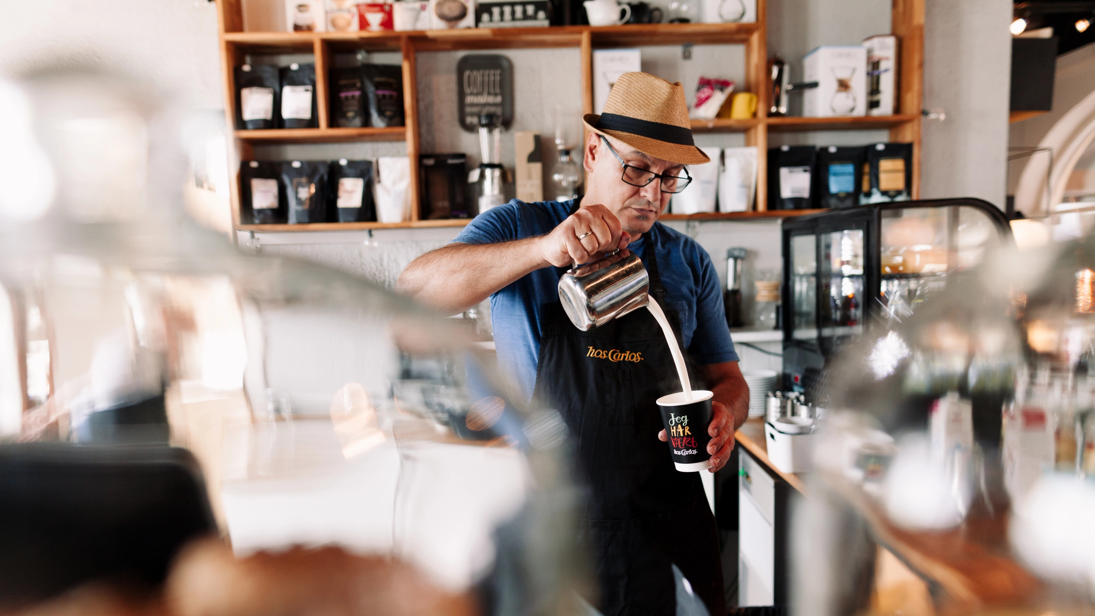 The barista at café Hos Carlos in Haugesund, Fjord Norway, is making a cup of coffee