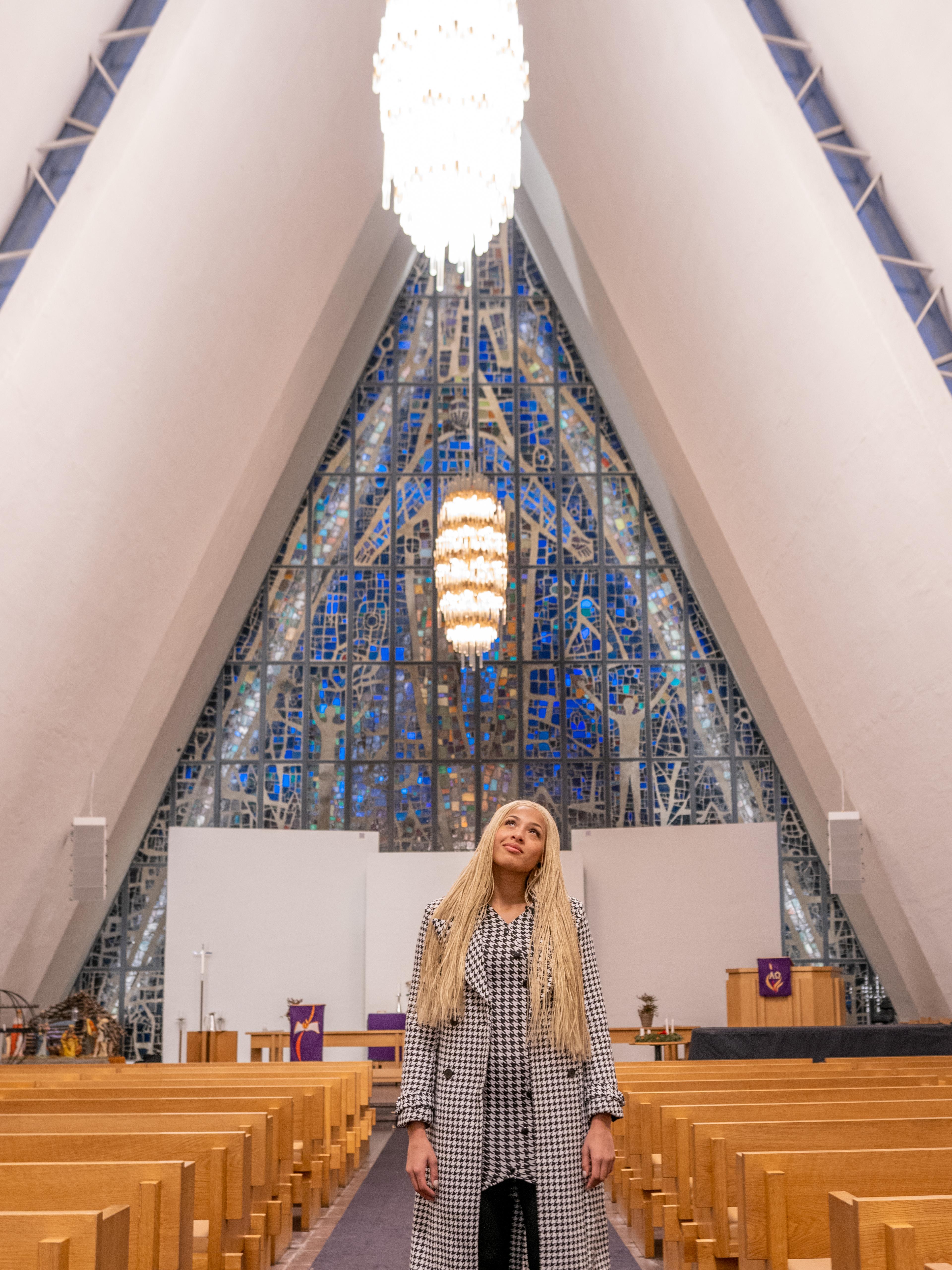 Artist Ida Tolou standing in the beautiful Arctic Cathedral in Tromsø