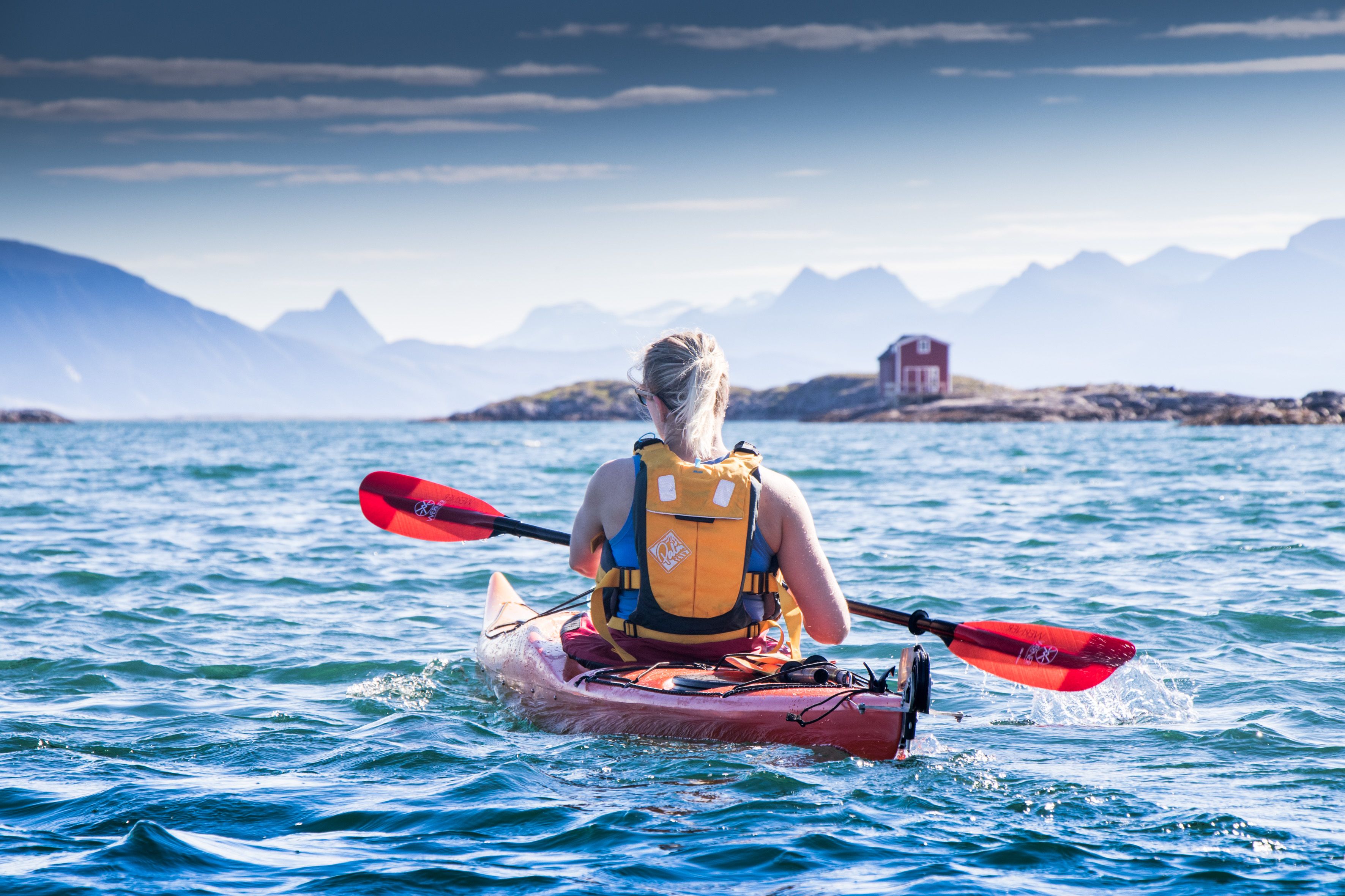 A woman kayaking at Helgelandskysten