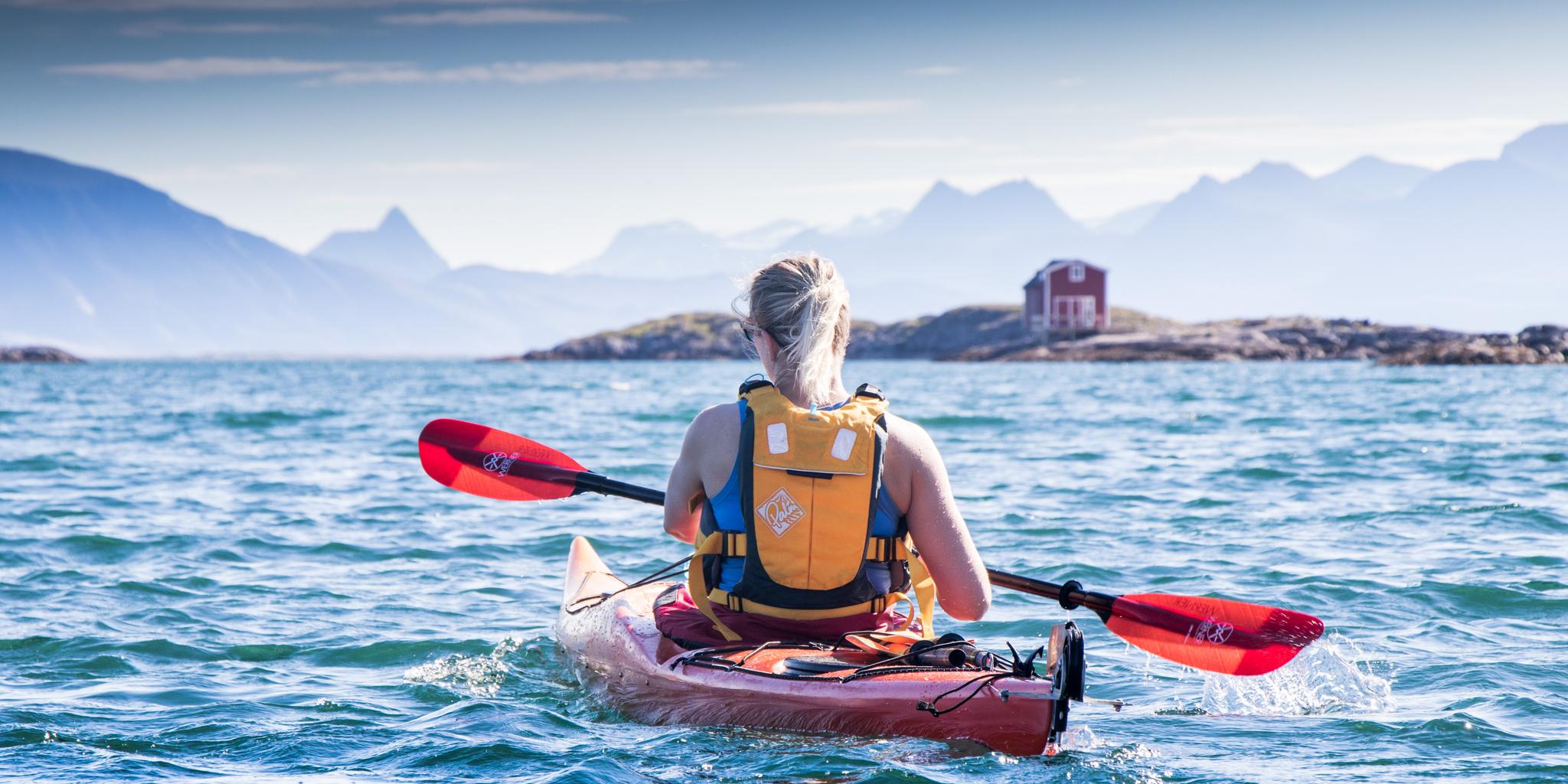 A woman kayaking at Helgelandskysten