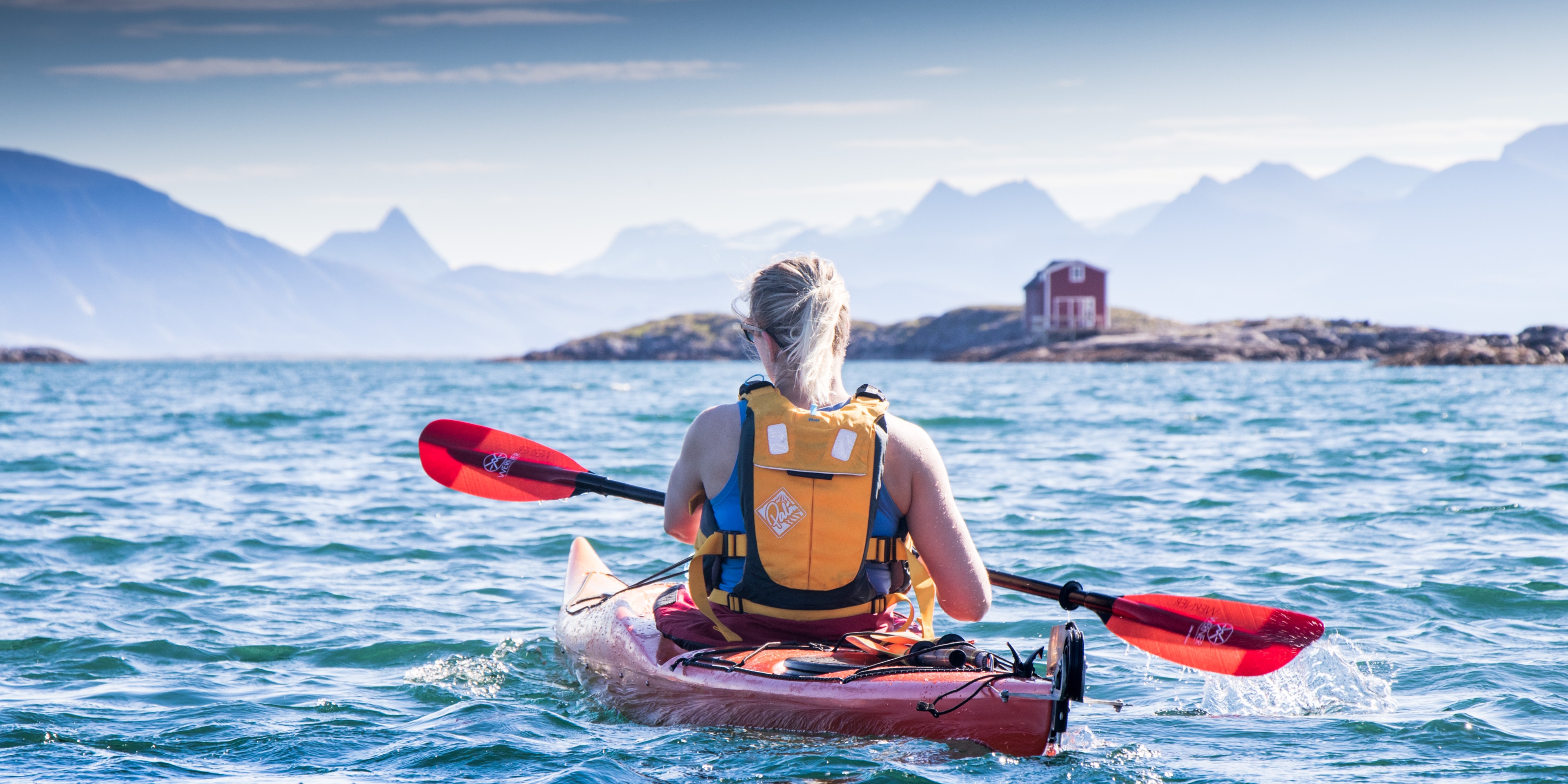 A woman kayaking at Helgelandskysten