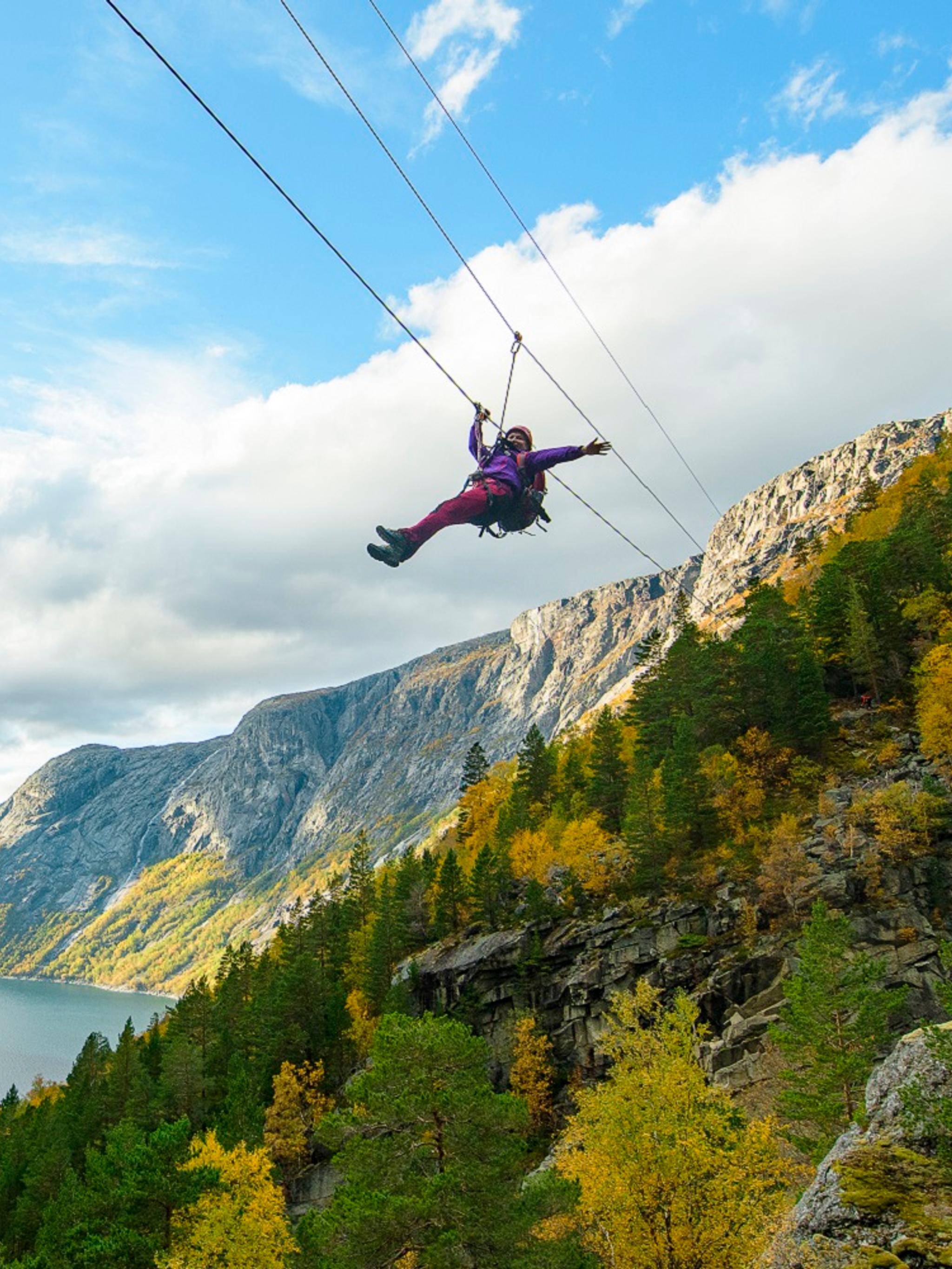 Woman sliding down a zipline near Trolltunga in Fjord Norway