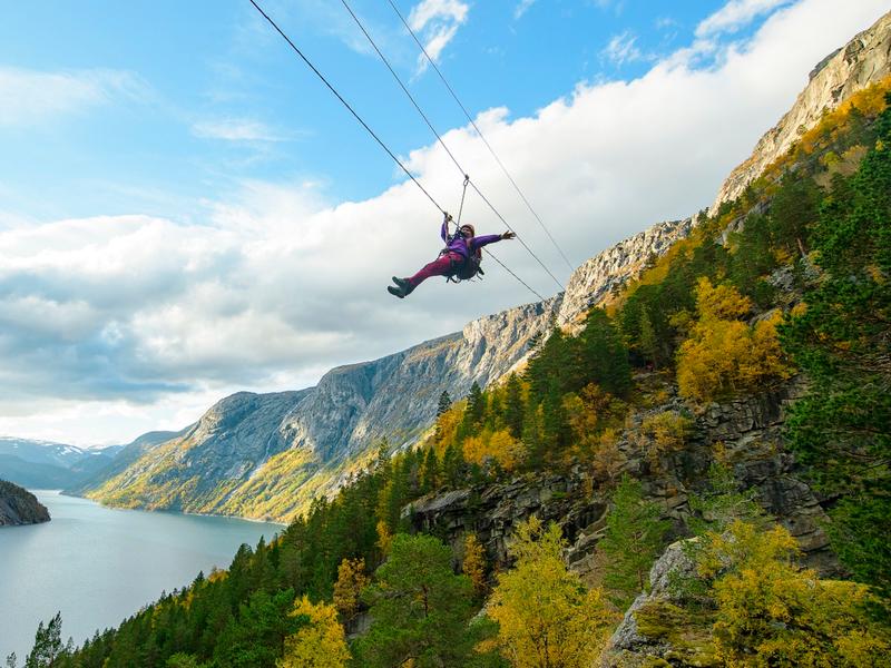 Woman sliding down a zipline near Trolltunga in Fjord Norway