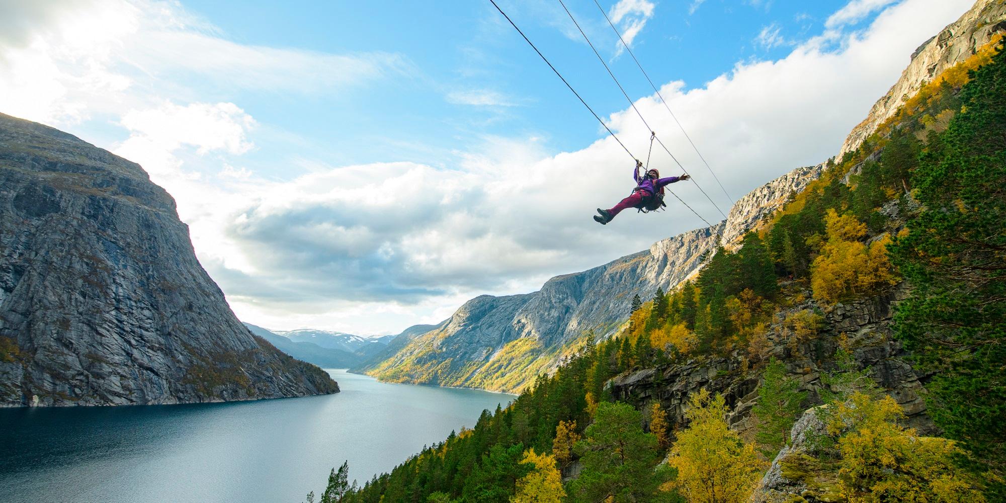 Woman sliding down a zipline near Trolltunga in Fjord Norway