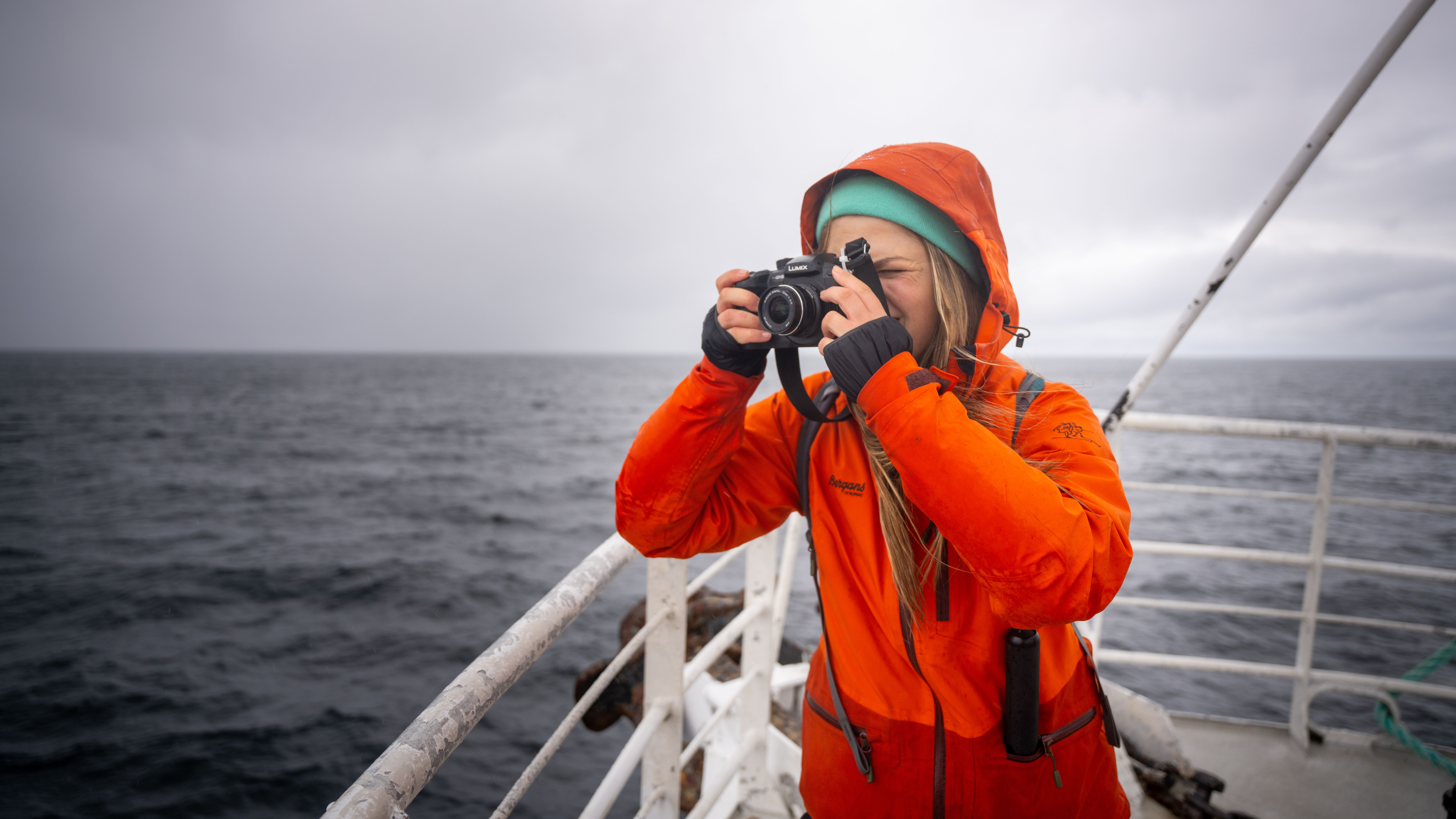 A tourist taking a picture of the whales on whale safari tour