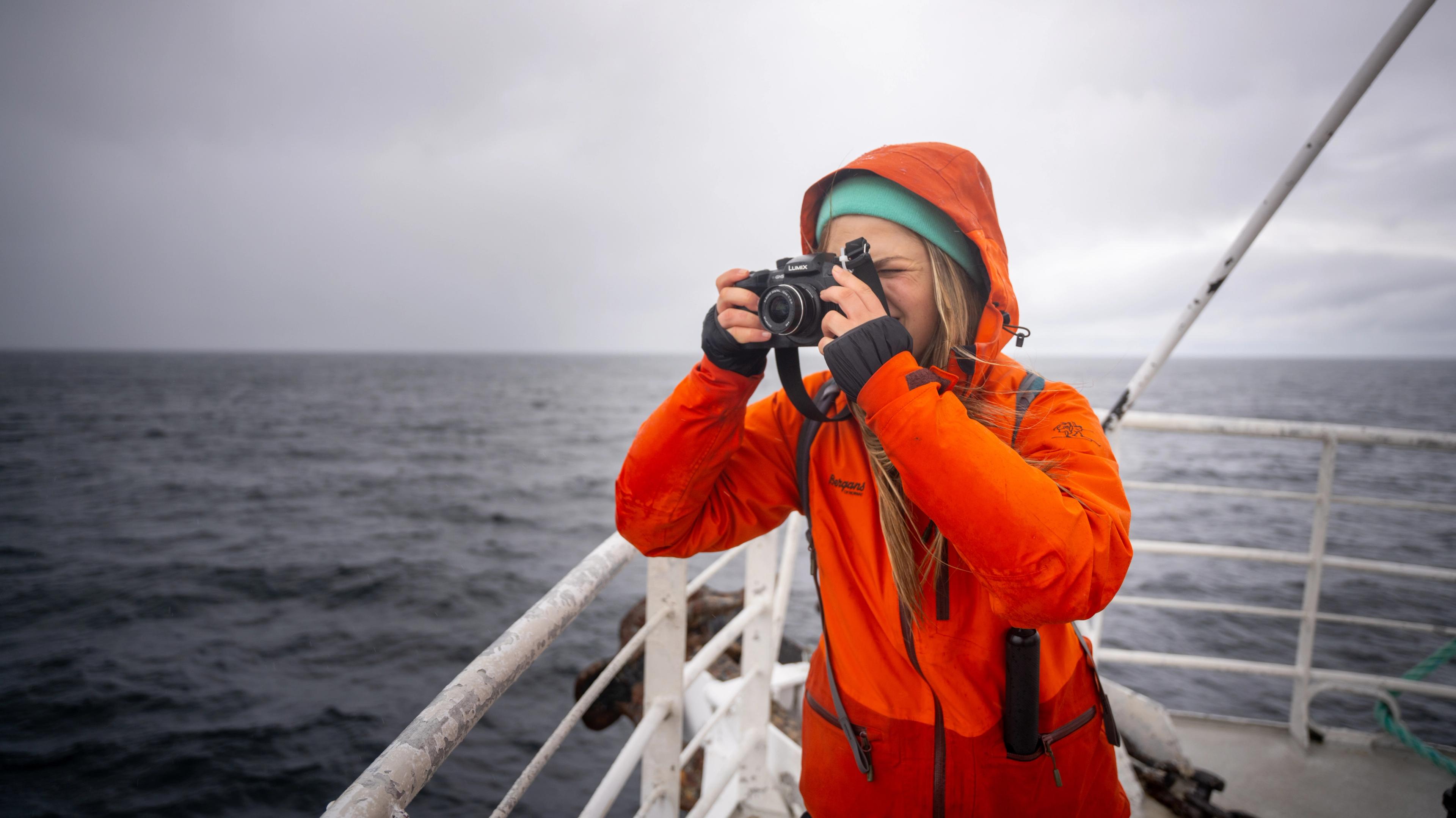 A tourist taking a picture of the whales on whale safari tour